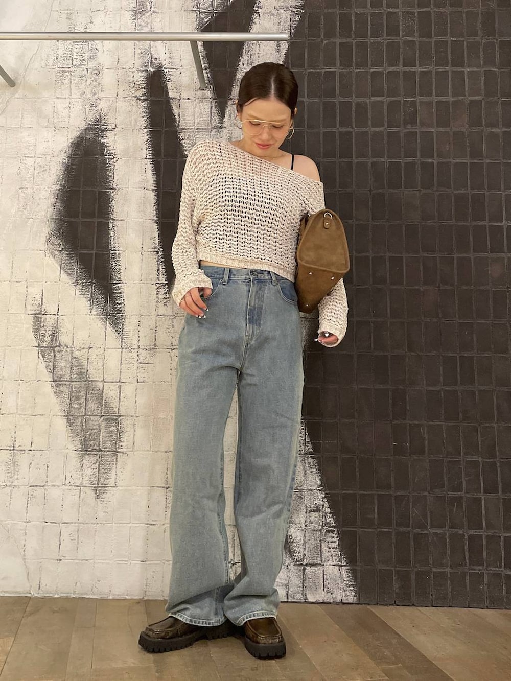 ブラウン系のローファー、ブルー系のデニムパンツ、ブラウン系のボストンバッグを着用したレディースの秋コーディネートの5枚目の写真