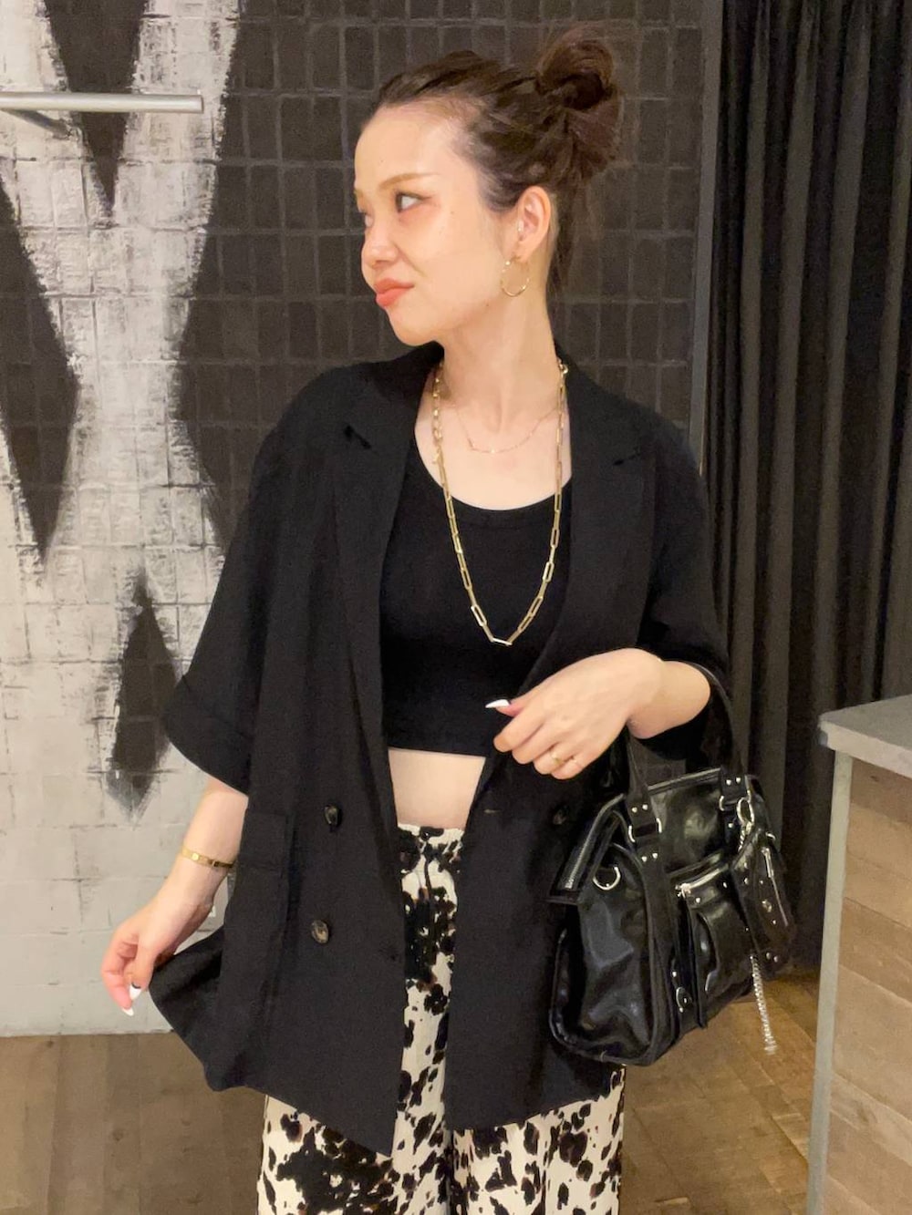 ブラック系のタンクトップ、ブラック系のボストンバッグ、ブラック系のサンダルを着用したレディースの夏コーディネートの3枚目の写真