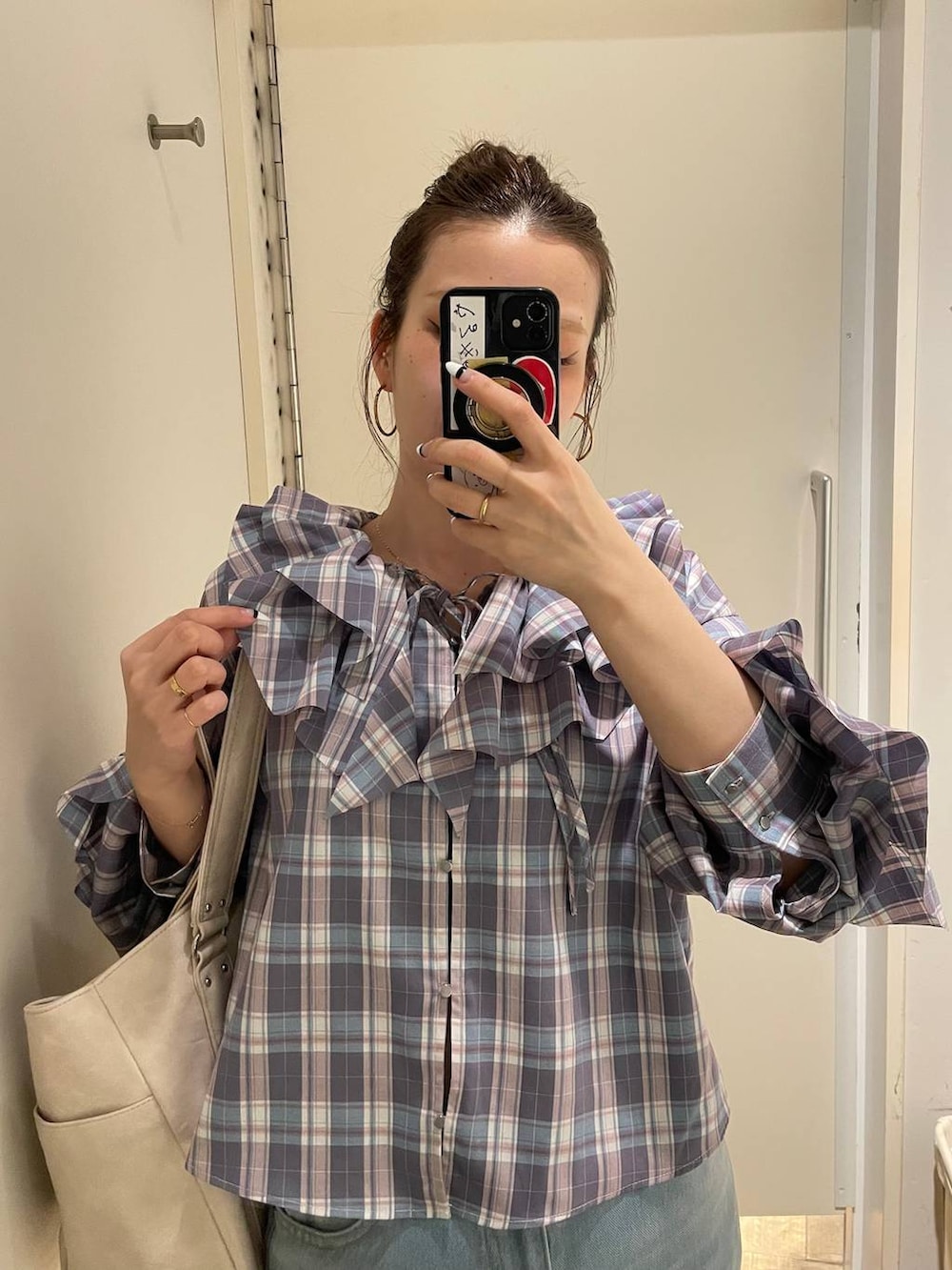 ピンク系のローファー、ホワイト系のトートバッグ、ブルー系のデニムパンツを着用したレディースの春コーディネートの3枚目の写真