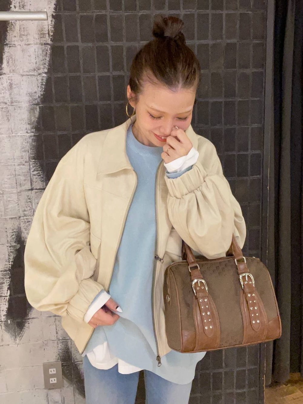 ブルー系のニット/セーター、ホワイト系のブルゾン、グリーン系のボストンバッグを着用したレディースの秋コーディネートの4枚目の写真