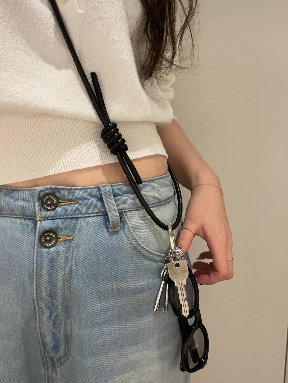 ブルー系のデニムパンツ、ホワイト系のポロシャツ、イエロー系のメガネを着用したレディースの冬コーディネートの3枚目の写真