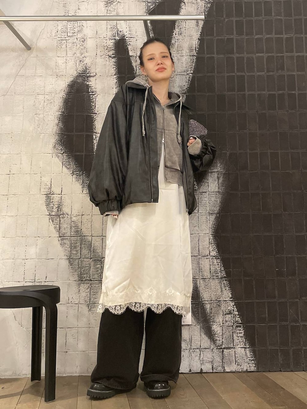 ブラック系のブルゾン、グレー系のパーカー、グレー系のデニムパンツを着用したレディースの冬コーディネートの6枚目の写真