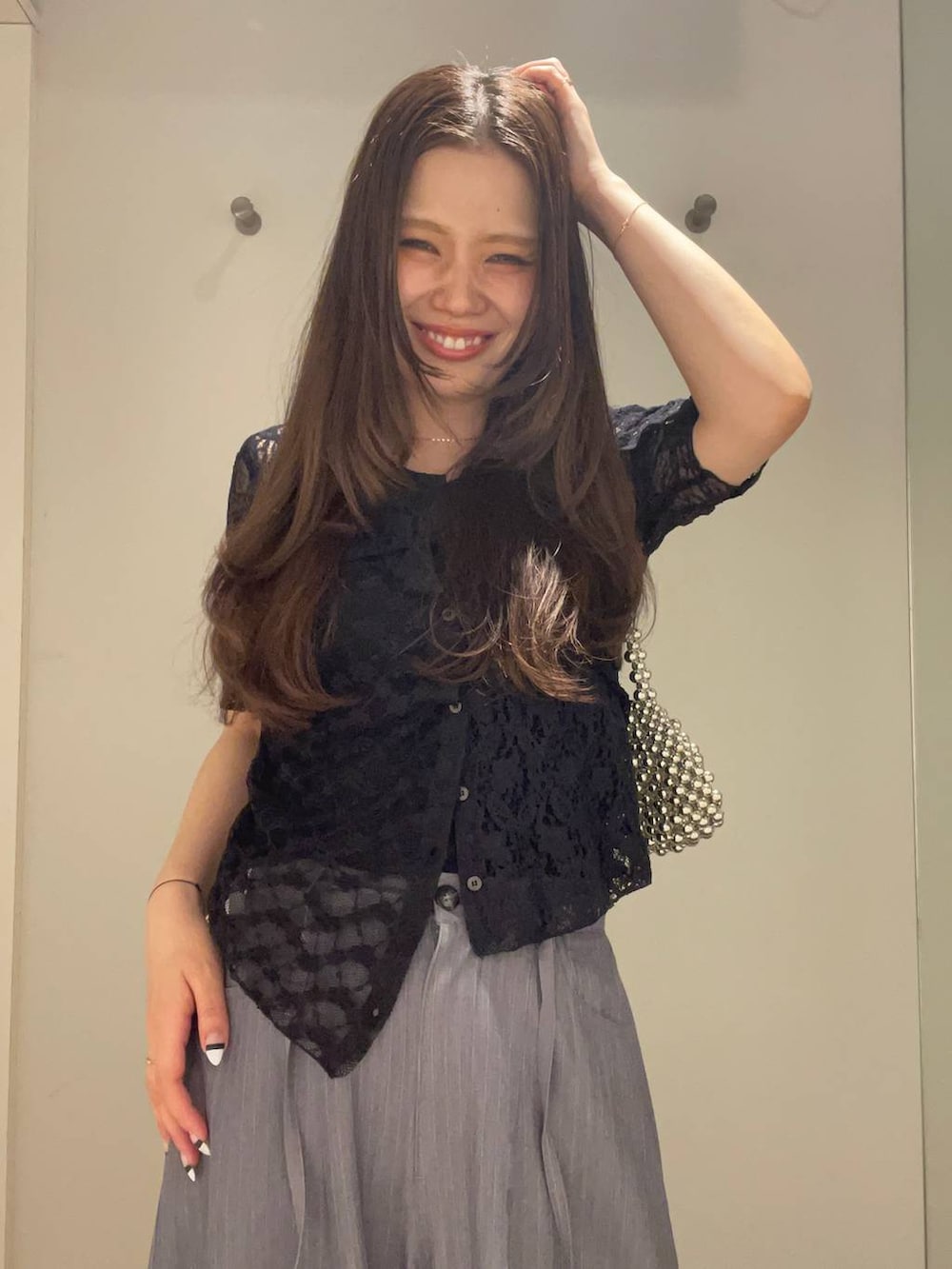 シルバー系のハンドバッグ、グレー系のスラックス、ブラック系のバレエシューズを着用したレディースの夏コーディネートの5枚目の写真