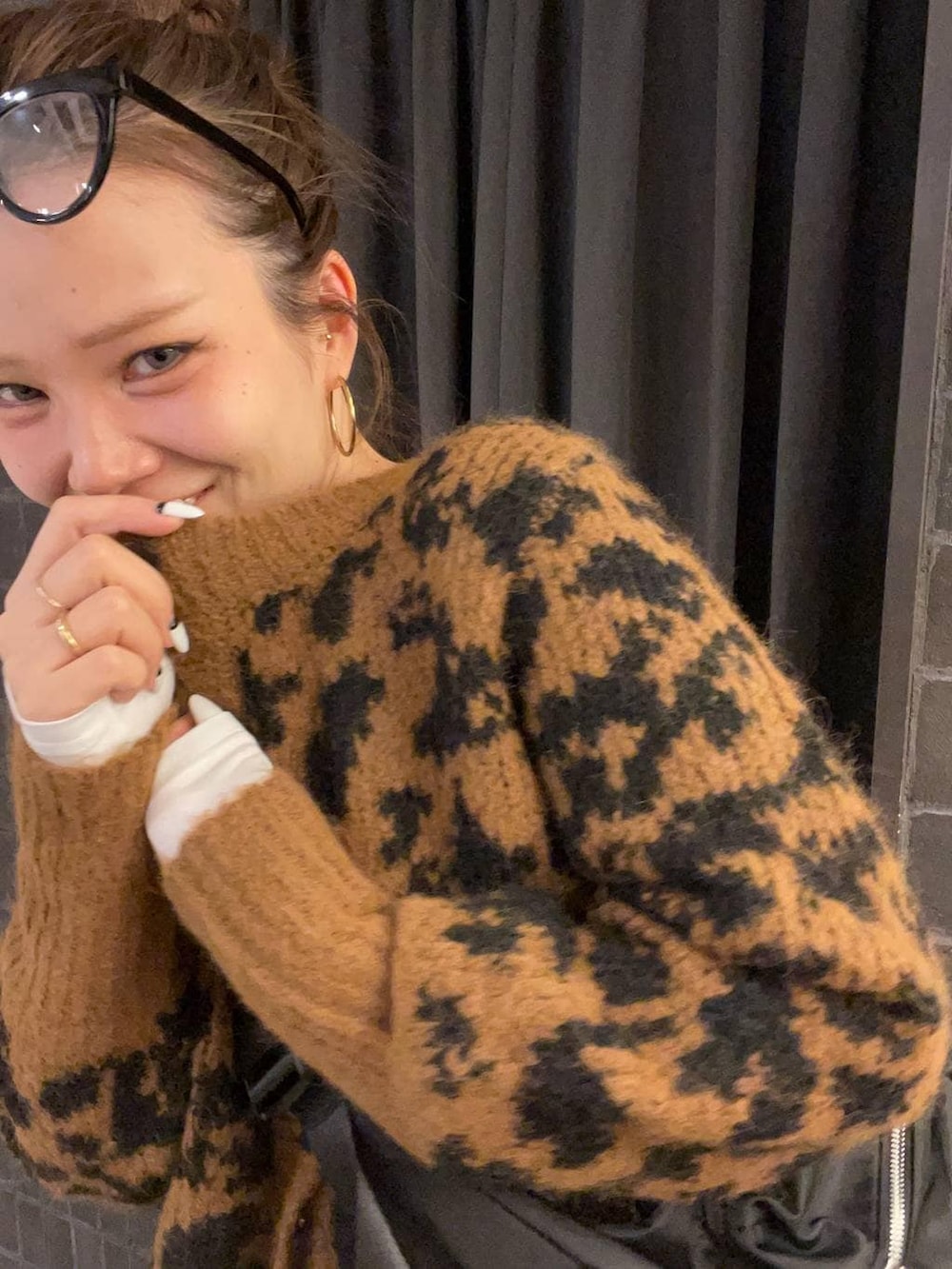 ブラック系のショルダーバッグ、ブルー系のデニムパンツ、ブラック系のブーツを着用したレディースの冬コーディネートの4枚目の写真