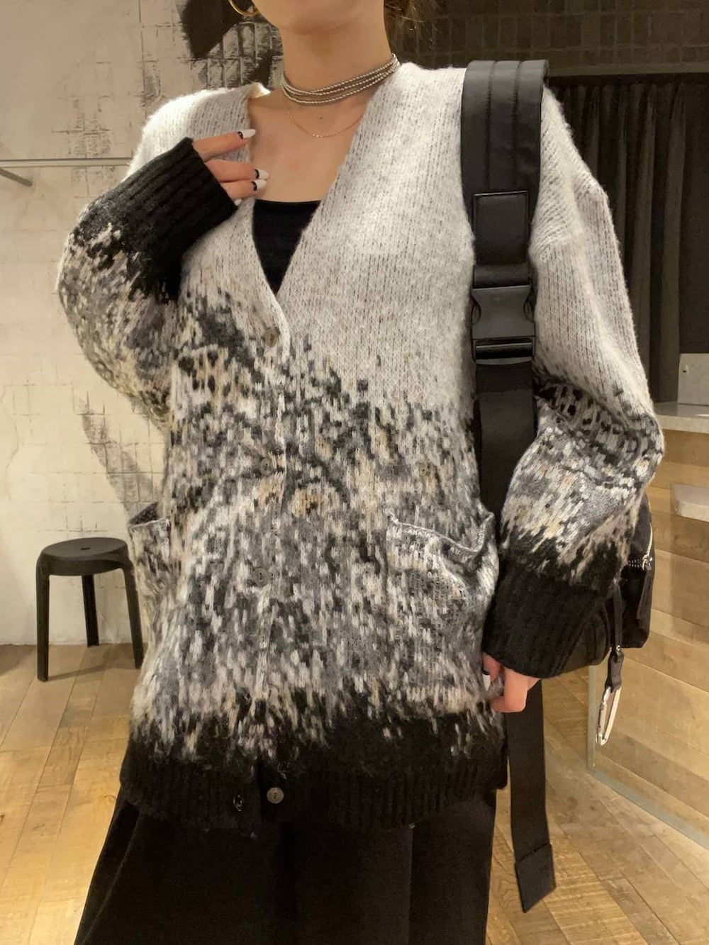 ブラック系のショルダーバッグ、ブラック系のブーツ、グレー系のカーディガン/ボレロを着用したレディースの冬コーディネートの3枚目の写真