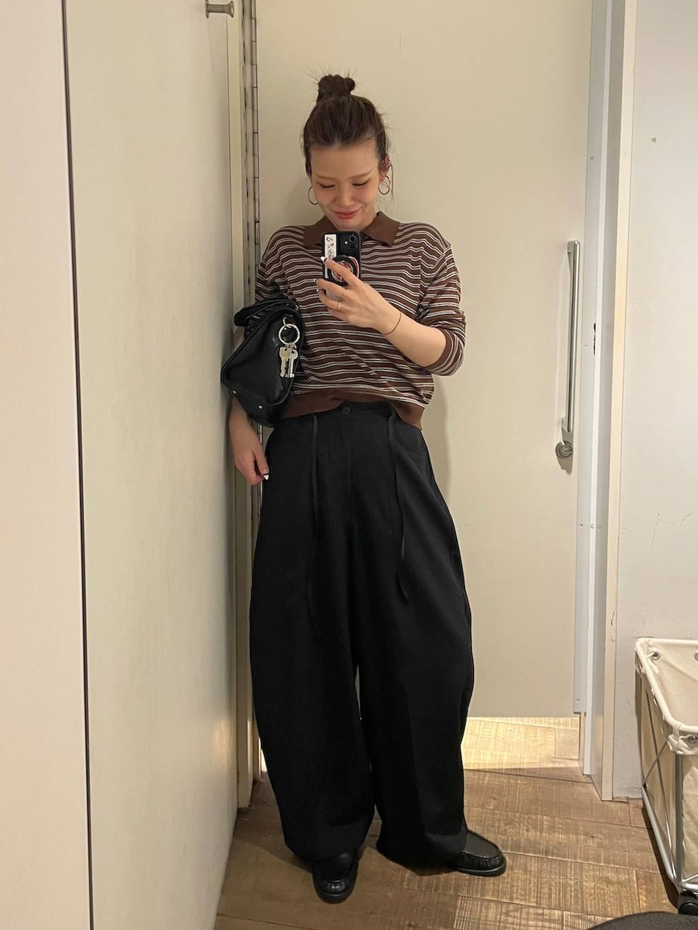 ブラック系のローファー、ブラック系のボストンバッグ、ブラック系のスラックスを着用したレディースの春コーディネートの2枚目の写真