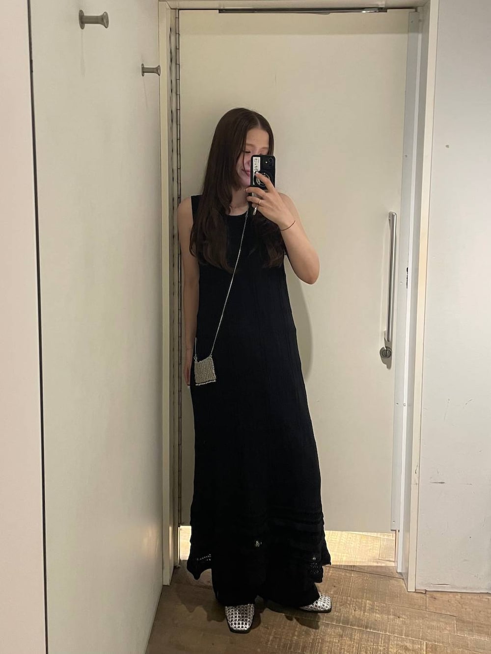 ブラック系のワンピース、シルバー系のパンプス、シルバー系のネックレスを着用したレディースの夏コーディネートの2枚目の写真