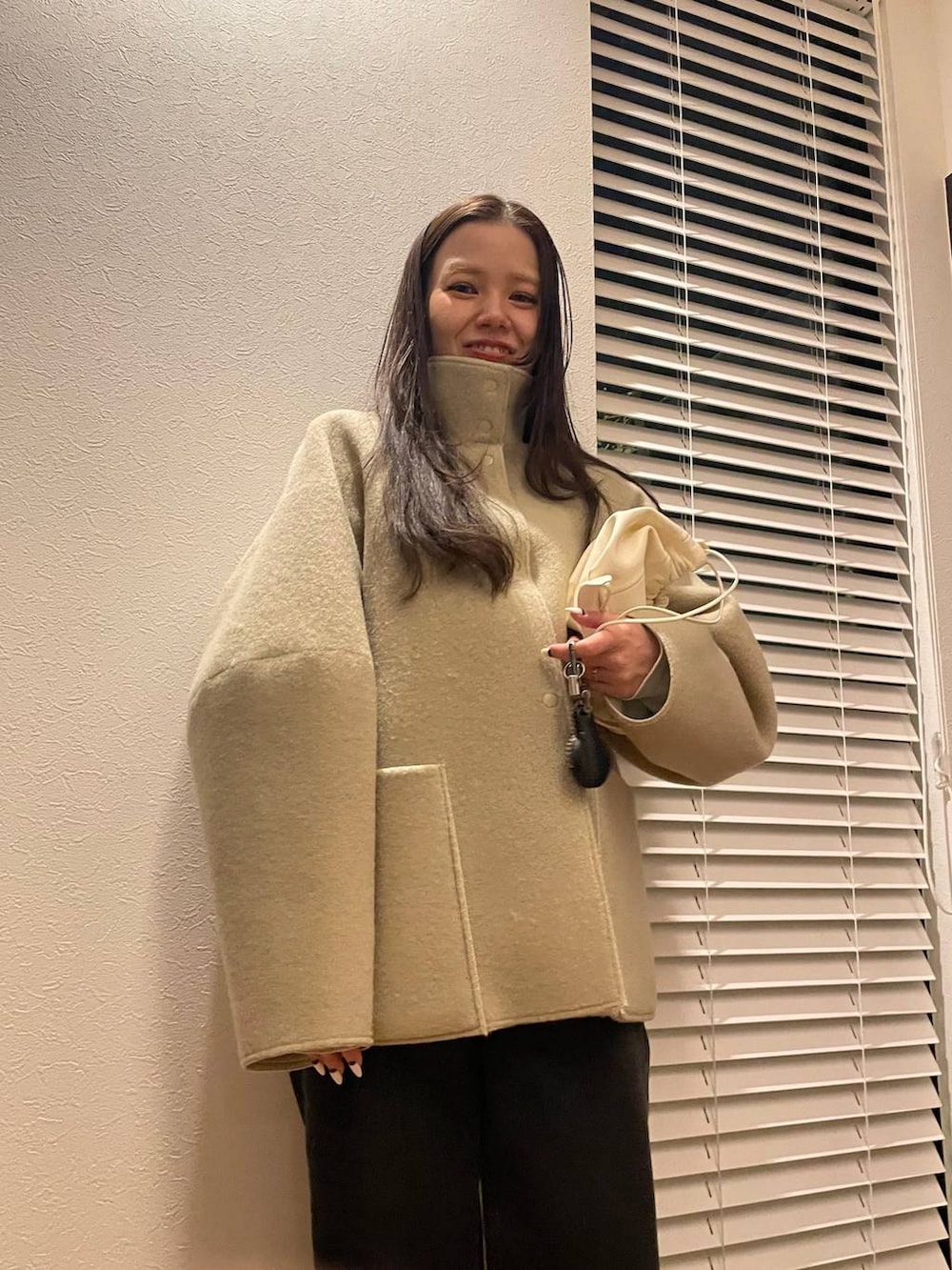 ベージュ系のブルゾン、ゴールド系のピアス（両耳用）を着用したレディースの冬コーディネートの2枚目の写真