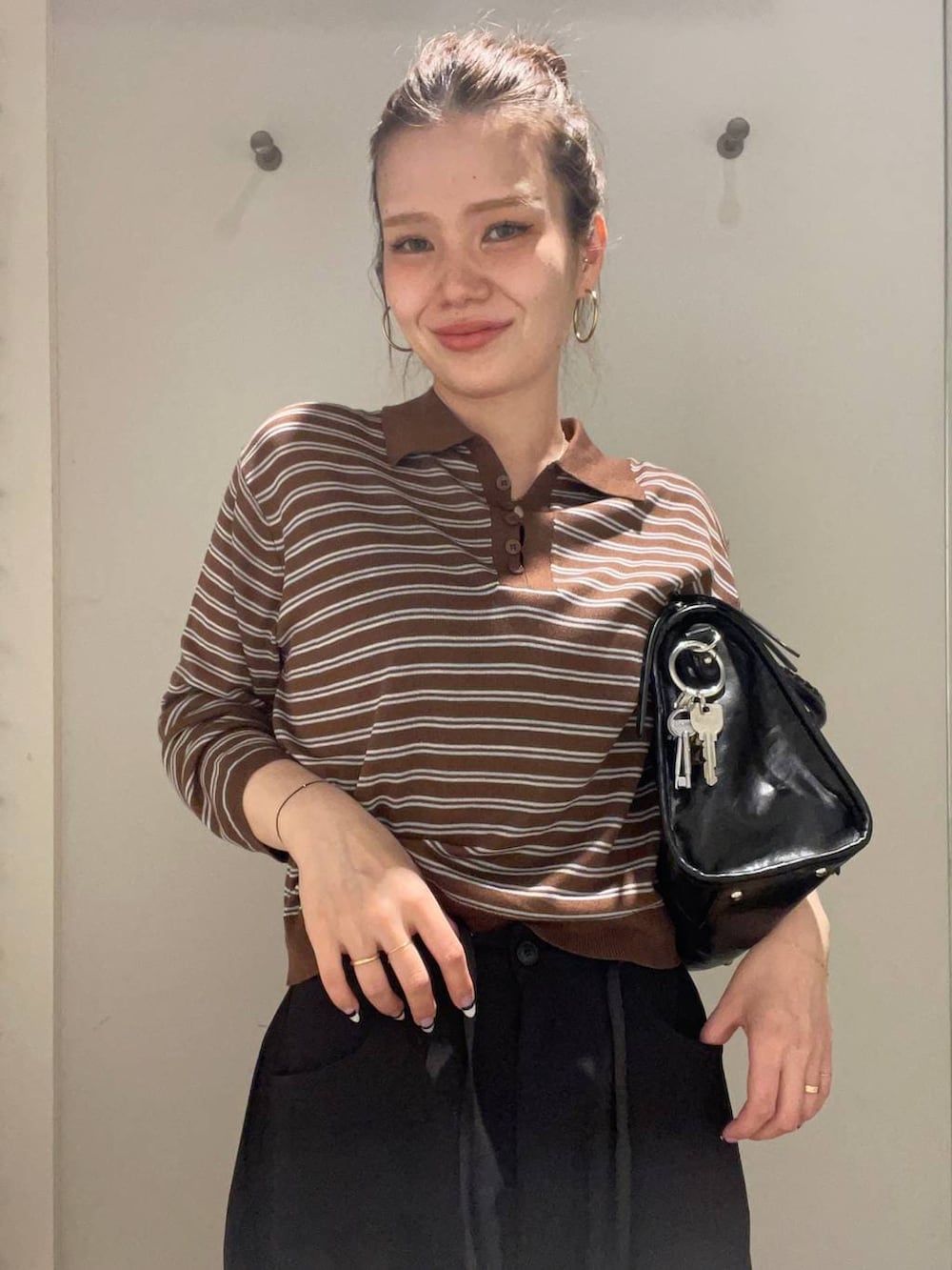 ブラック系のローファー、ブラック系のボストンバッグ、ブラック系のスラックスを着用したレディースの春コーディネートの6枚目の写真