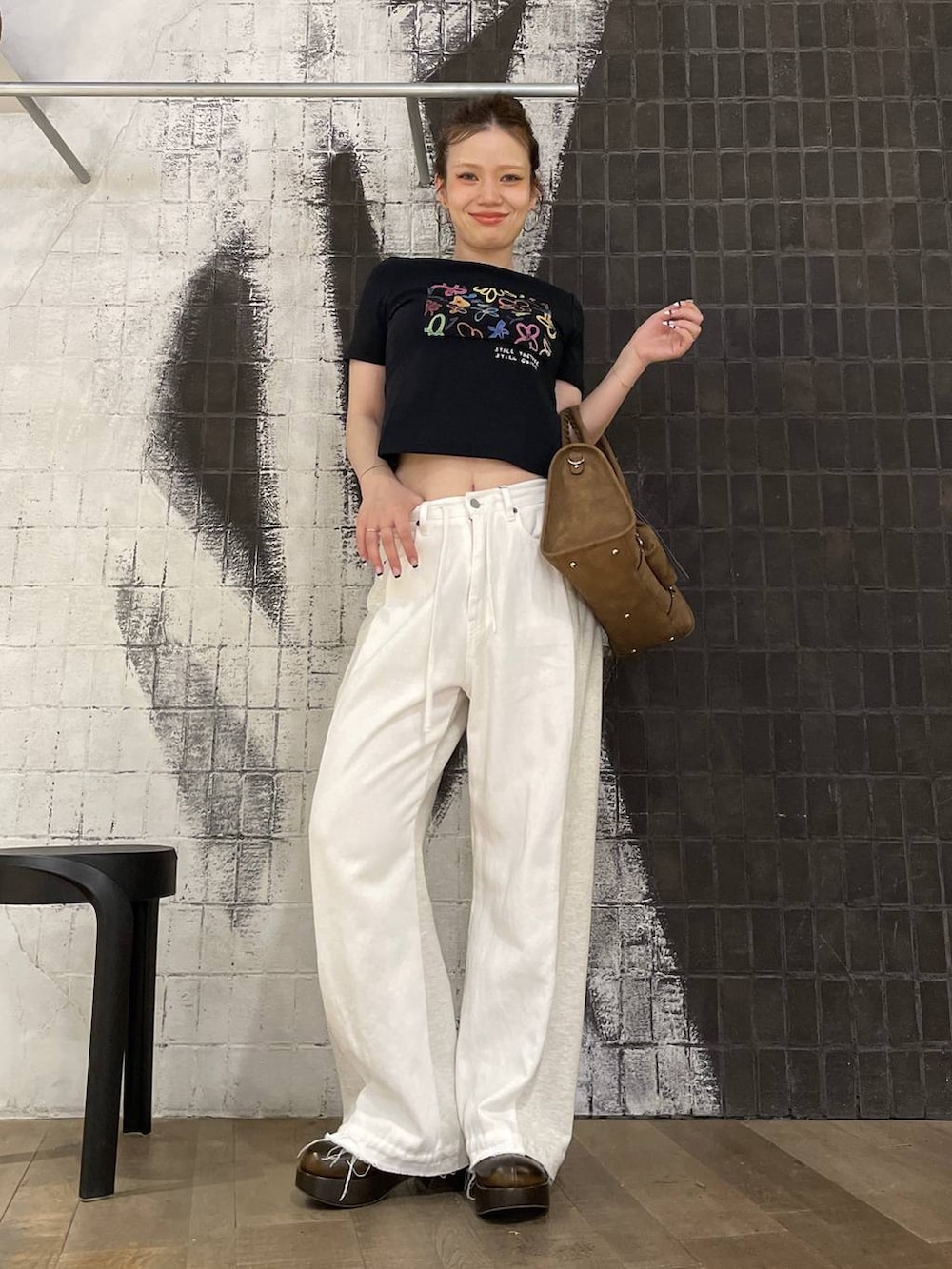 ブラック系のTシャツ/カットソー、ホワイト系のデニムパンツ、ブラウン系のボストンバッグを着用したレディースの夏コーディネートの5枚目の写真