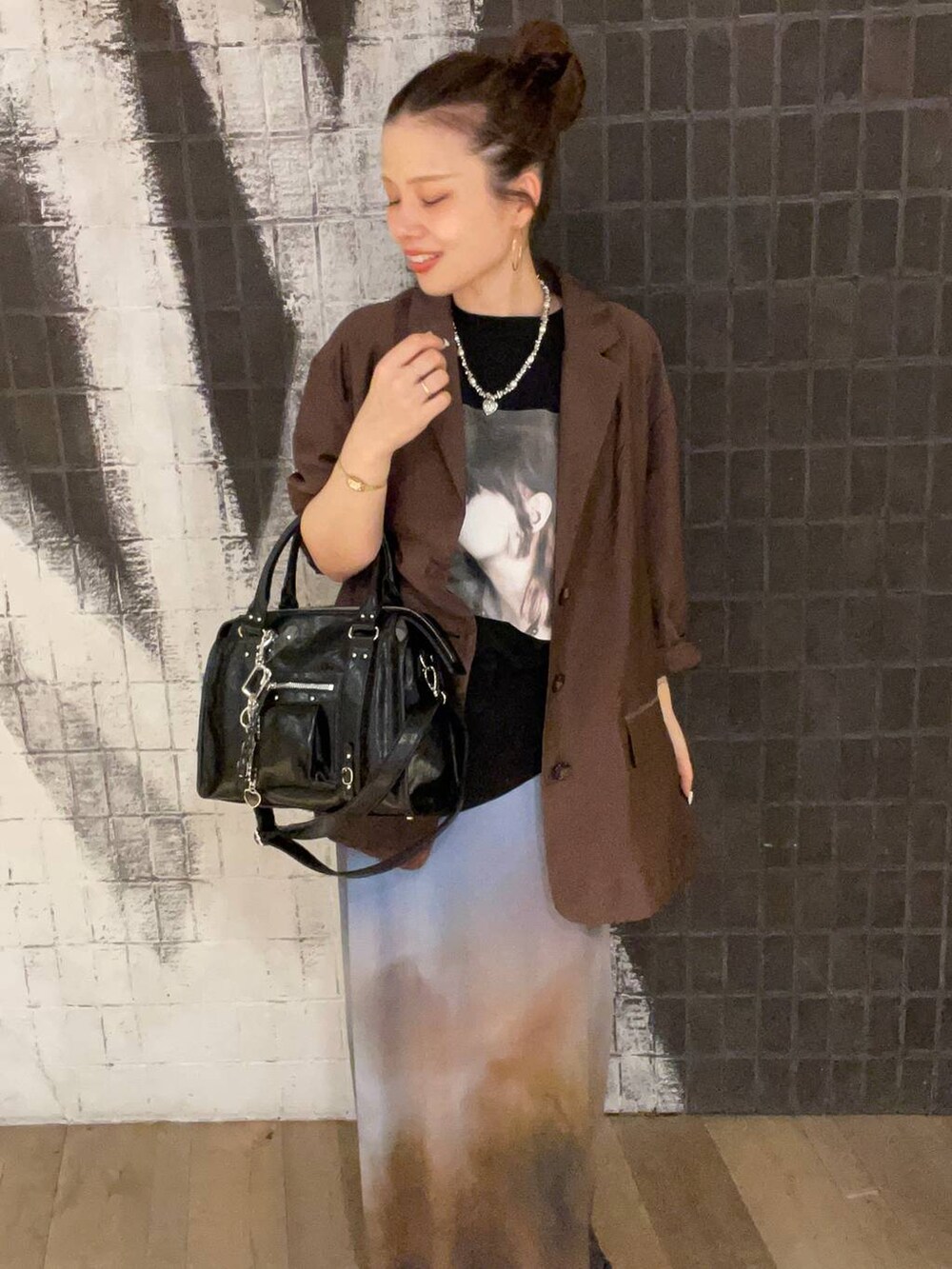 ブラック系のボストンバッグ、ブラック系のサンダル、ブラウン系のテーラードジャケットを着用したレディースの夏コーディネートの3枚目の写真