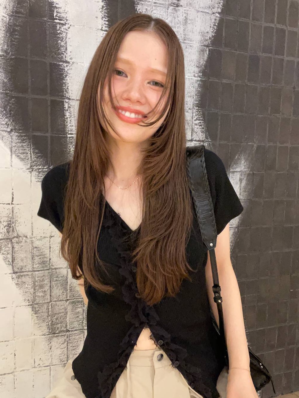 ベージュ系のその他パンツ、ブラック系のショルダーバッグ、ブラック系のサンダルを着用したレディースの夏コーディネートの3枚目の写真