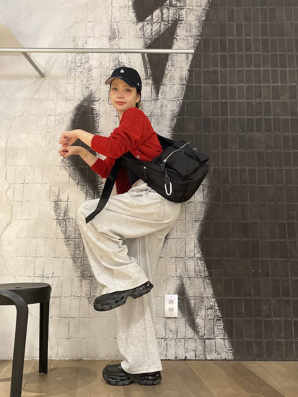 ブラック系のショルダーバッグ、ブラック系のブーツ、グレー系のスウェットパンツを着用したレディースの秋コーディネートの6枚目の写真