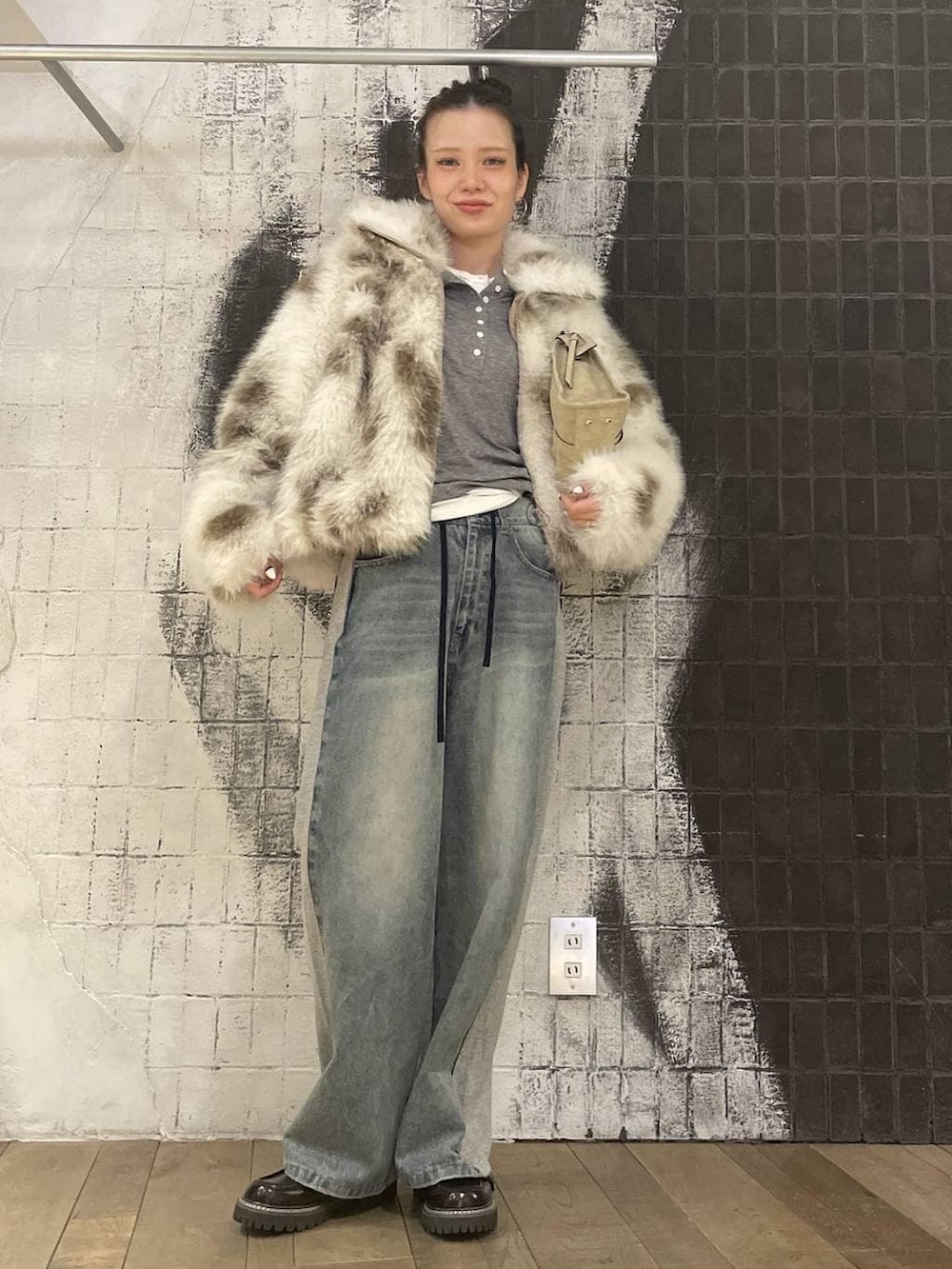 ベージュ系のボストンバッグ、ホワイト系のTシャツ/カットソー、グレー系のTシャツ/カットソーを着用したレディースの冬コーディネートの3枚目の写真