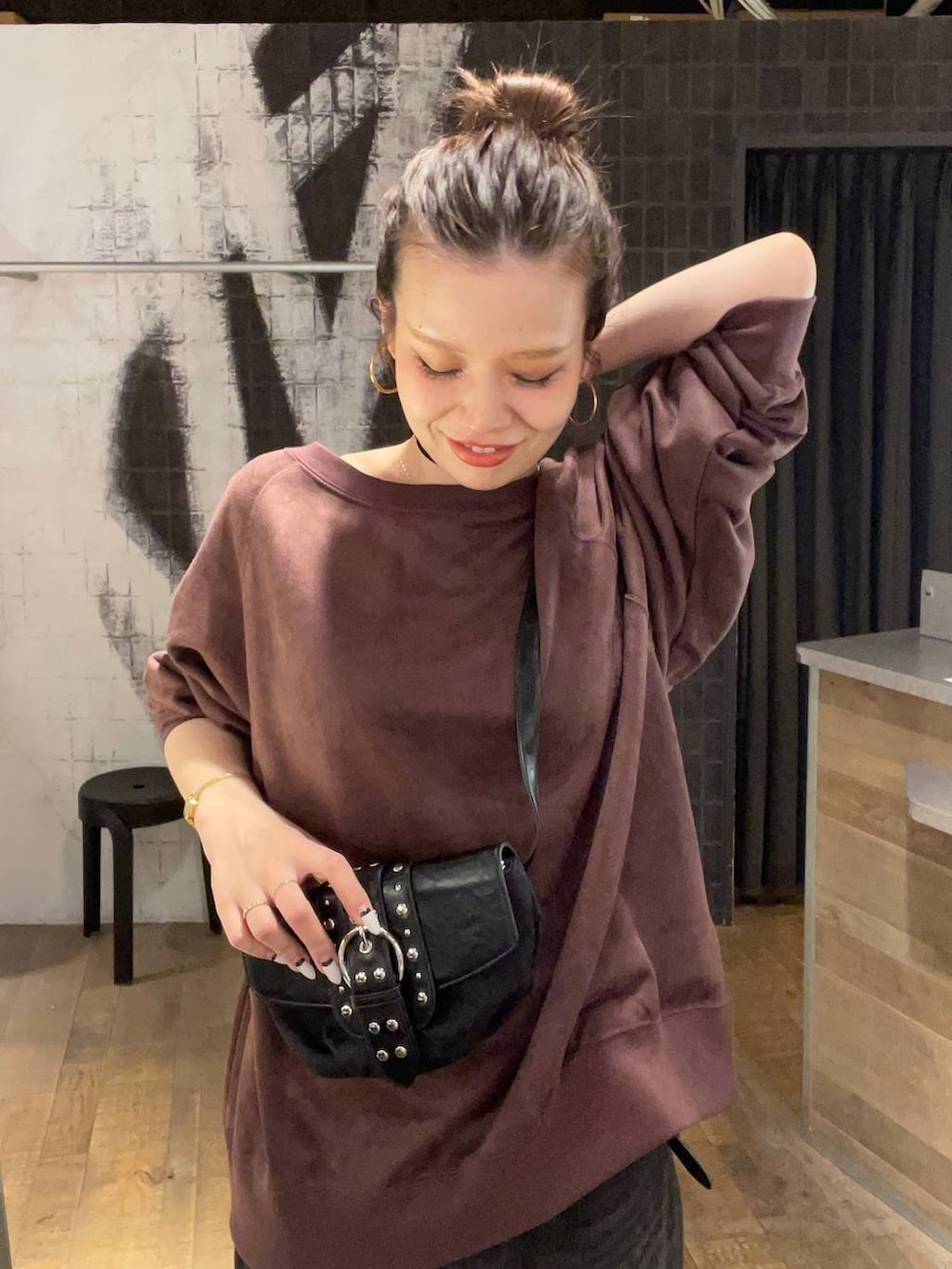 グレー系のデニムパンツ、ブラック系のショルダーバッグ、ブラック系のブーツを着用したレディースの秋コーディネートの5枚目の写真