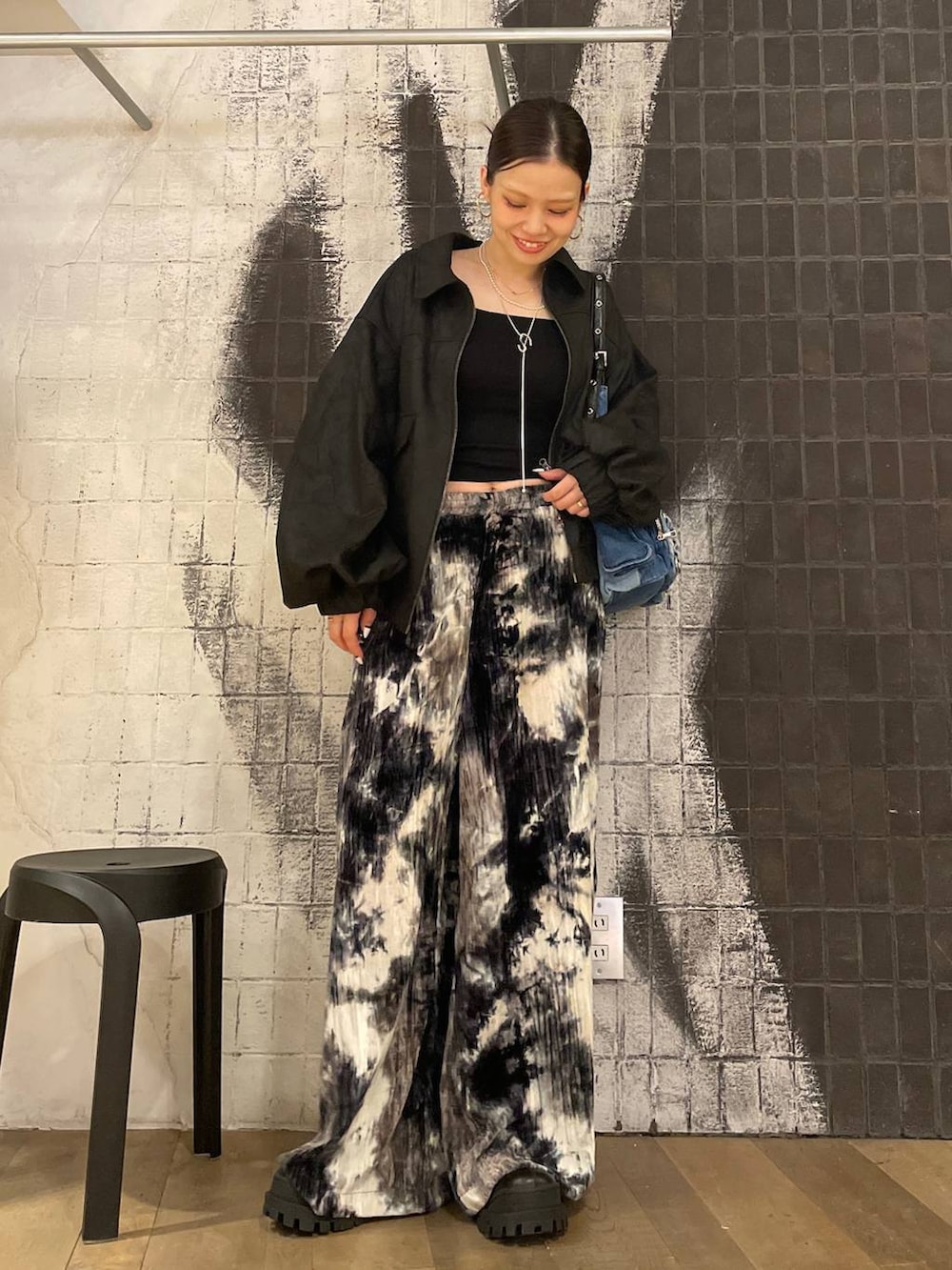 ブラック系のブルゾン、ブルー系のショルダーバッグ、ブラック系のブーツを着用したレディースの秋コーディネートの3枚目の写真