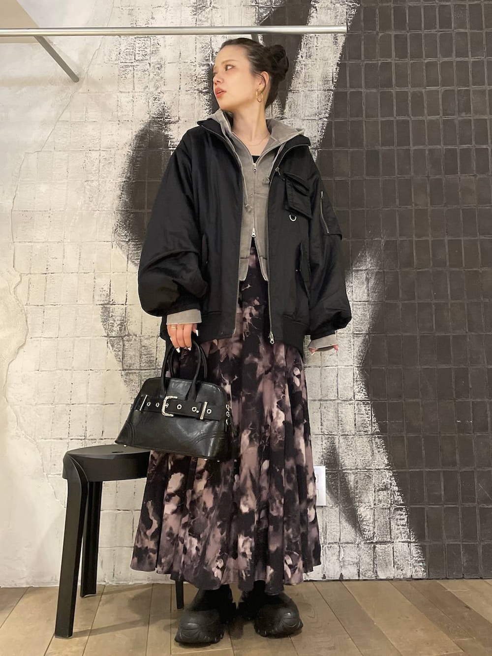 グレー系のパーカー、ブラック系のブーツ、ブラック系のブルゾンを着用したレディースの冬コーディネートの3枚目の写真