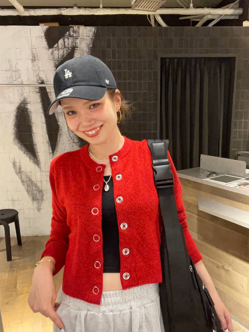 ブラック系のショルダーバッグ、ブラック系のブーツ、グレー系のスウェットパンツを着用したレディースの秋コーディネートの3枚目の写真