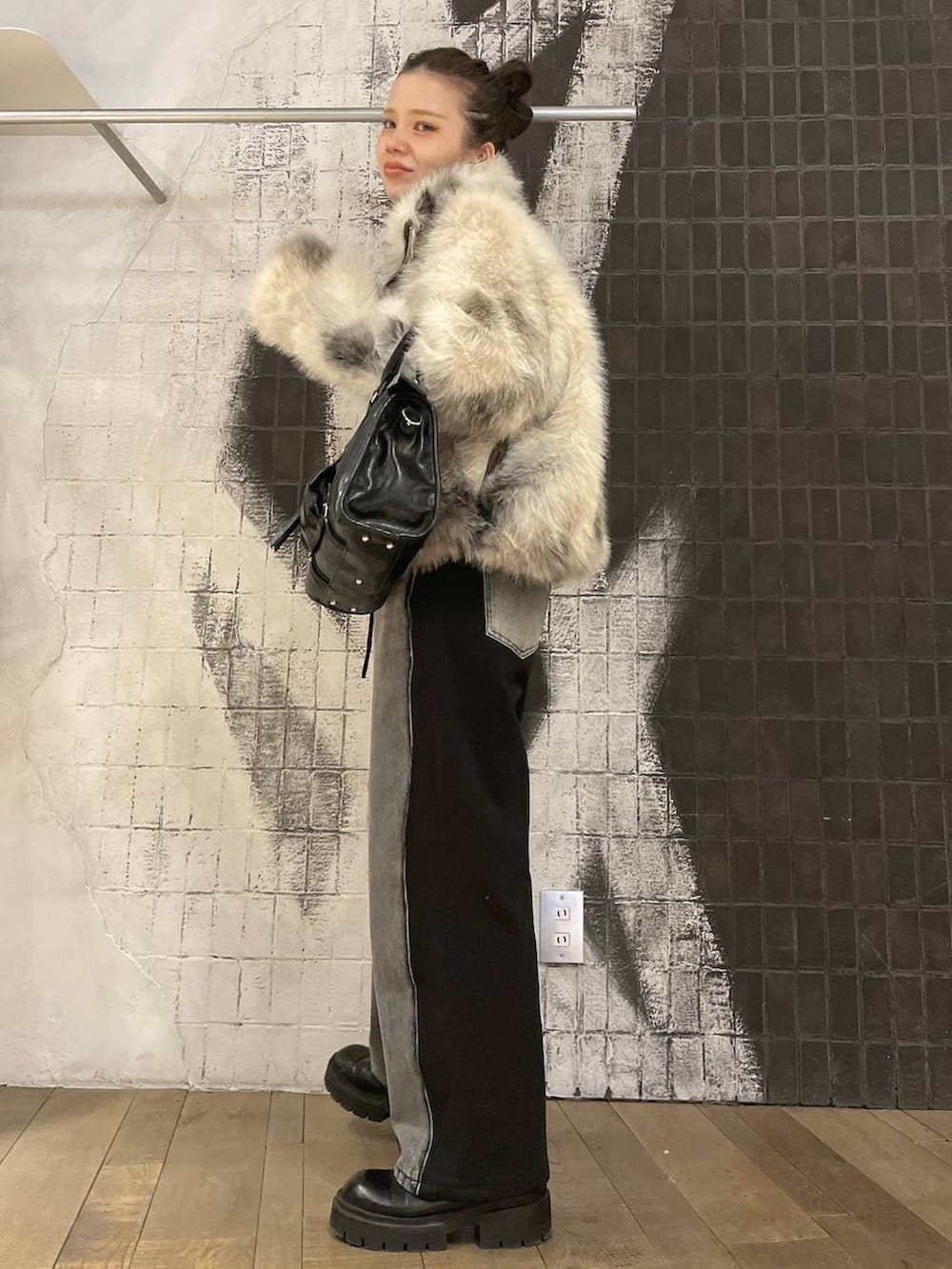 グレー系のブルゾン、ブラック系のボストンバッグ、ブラック系のデニムパンツを着用したレディースの冬コーディネートの4枚目の写真