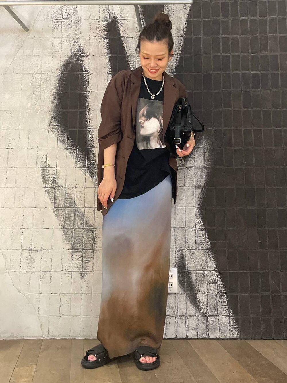 ブラック系のボストンバッグ、ブラック系のサンダル、ブラウン系のテーラードジャケットを着用したレディースの夏コーディネートの2枚目の写真