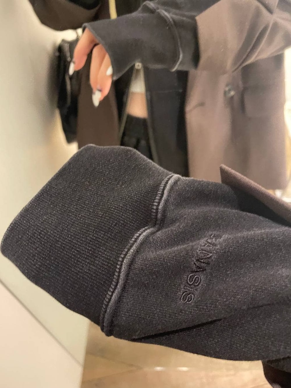 ブラック系のパーカー、ブラック系のスウェットパンツ、ホワイト系のキャミソールを着用したレディースの冬コーディネートの4枚目の写真