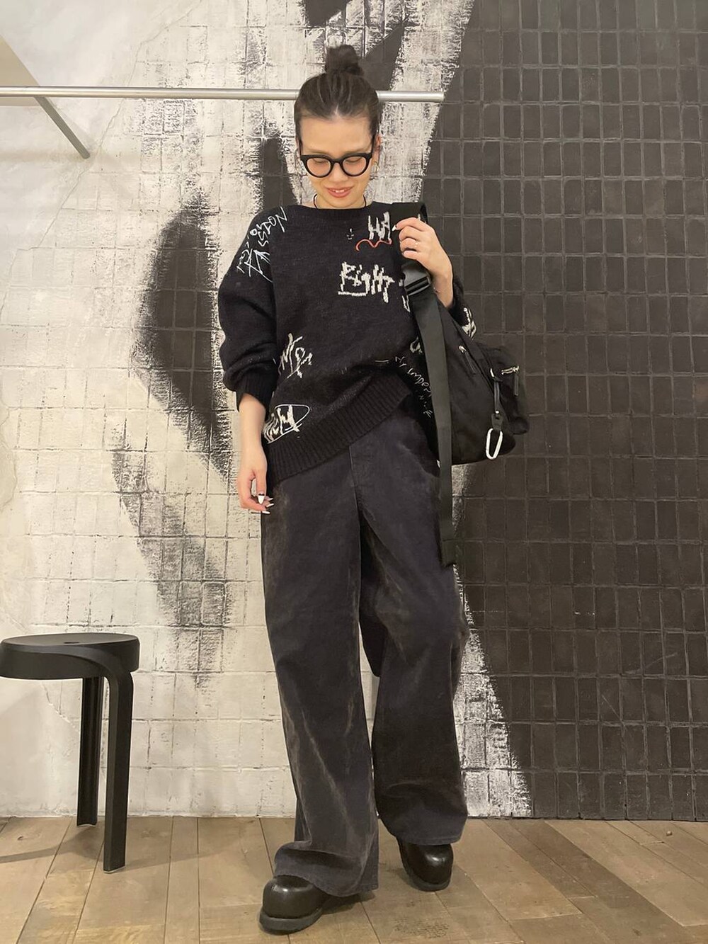 ブラック系のショルダーバッグ、ブラック系のその他シューズ、ブラウン系のデニムパンツを着用したレディースの冬コーディネートの5枚目の写真