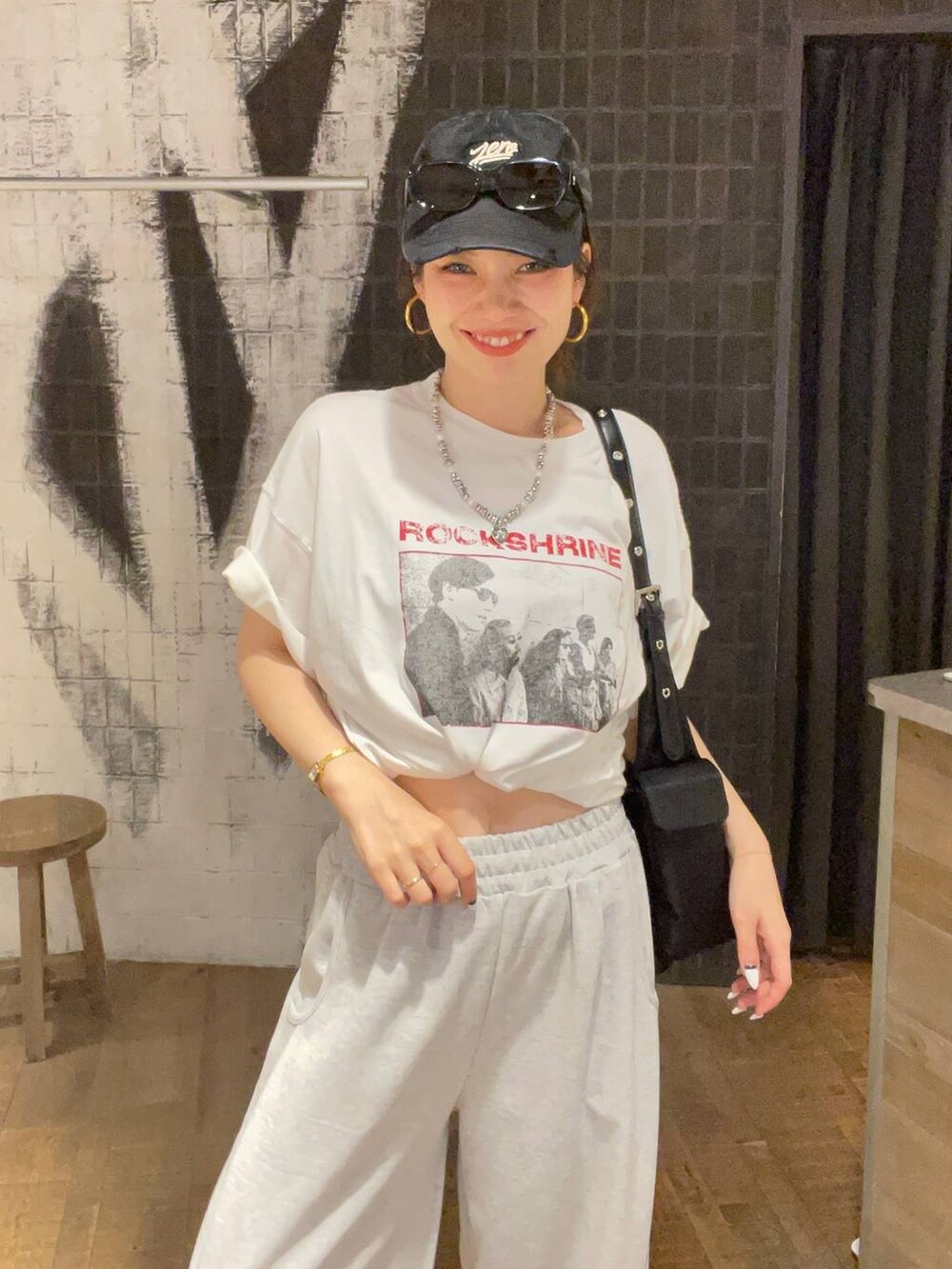 ブラック系のサンダル、ブラック系のショルダーバッグ、グレー系のスウェットパンツを着用したレディースの夏コーディネートの5枚目の写真