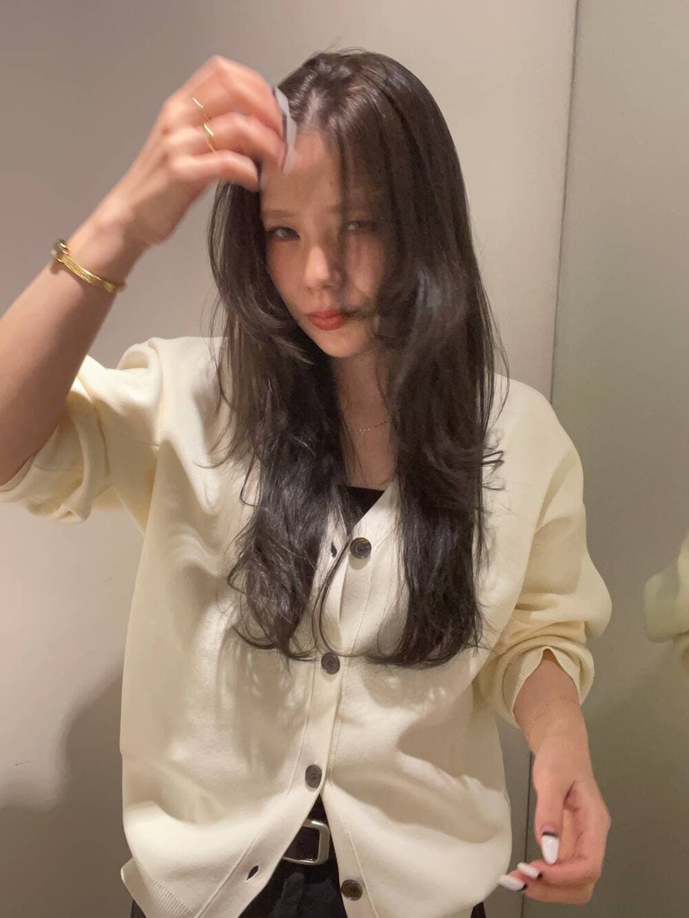 グレー系のデニムパンツ、ホワイト系のカーディガン/ボレロを着用したレディースの秋コーディネートの2枚目の写真