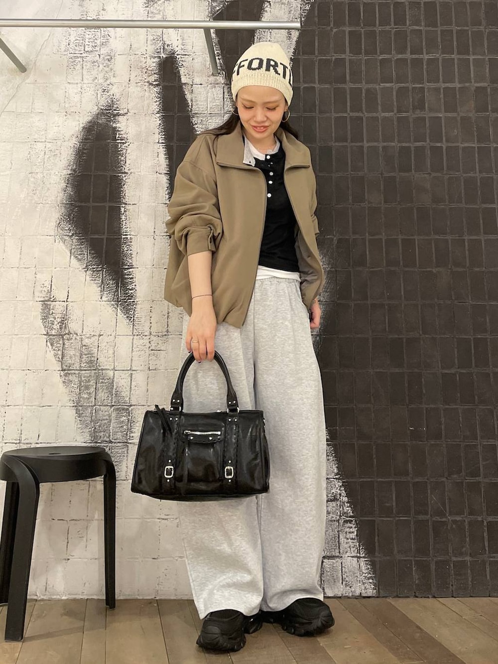 ブラック系のローファー、ブラウン系のボストンバッグ、グレー系のスウェットパンツを着用したレディースの春コーディネートの4枚目の写真