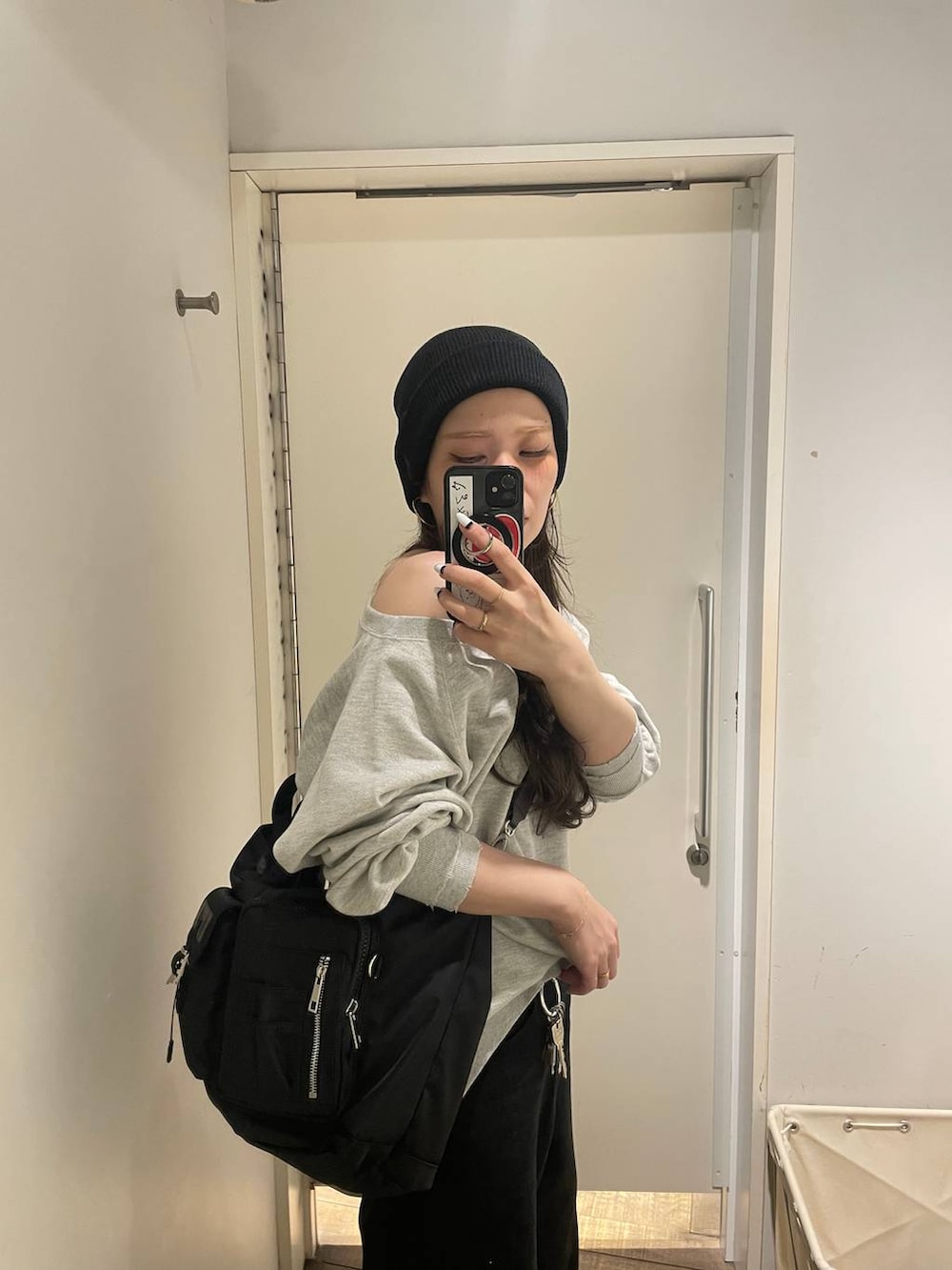 グレー系のスウェット、ブラック系のトートバッグ、ブラック系のデニムパンツを着用したレディースの冬コーディネートの4枚目の写真