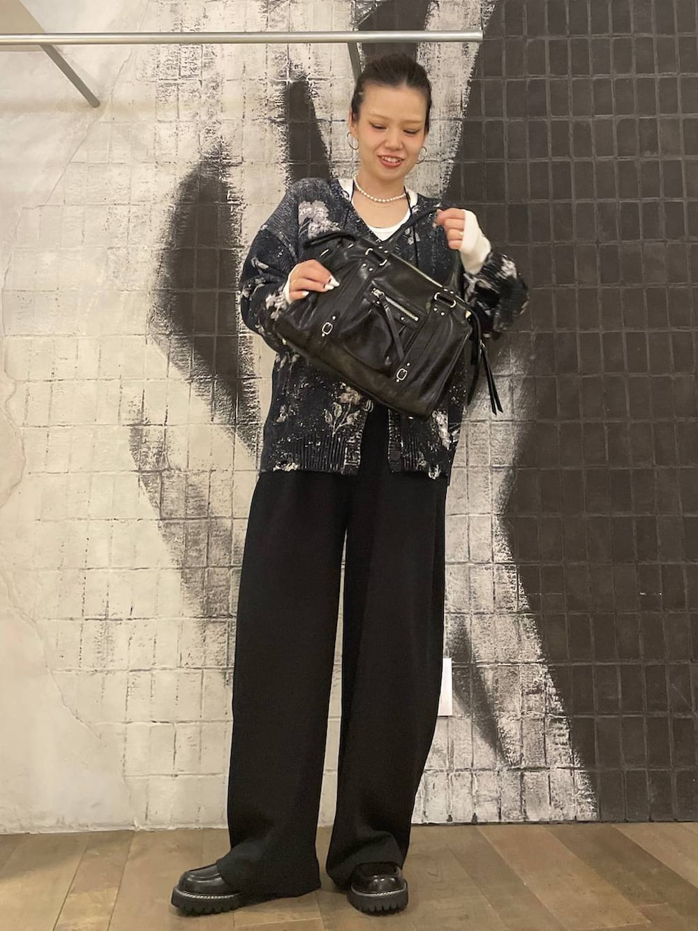 ホワイト系のTシャツ/カットソー、ブラック系のボストンバッグ、ブラック系のスラックスを着用したレディースの秋コーディネートの4枚目の写真