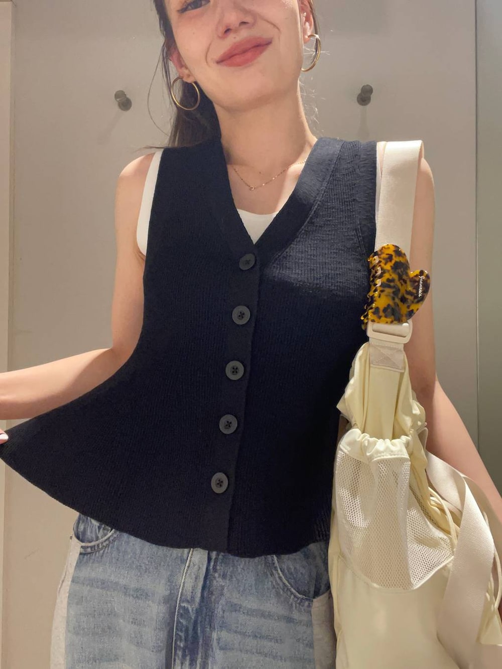 ブルー系のデニムパンツ、ホワイト系のタンクトップ、ベージュ系のサンダルを着用したレディースの春コーディネートの2枚目の写真