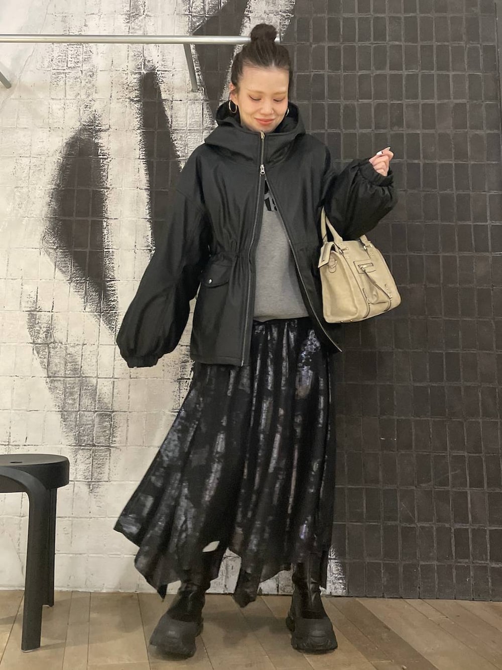 ベージュ系のボストンバッグ、ブラック系のブーツ、ブラック系のスカートを着用したレディースの冬コーディネートの4枚目の写真