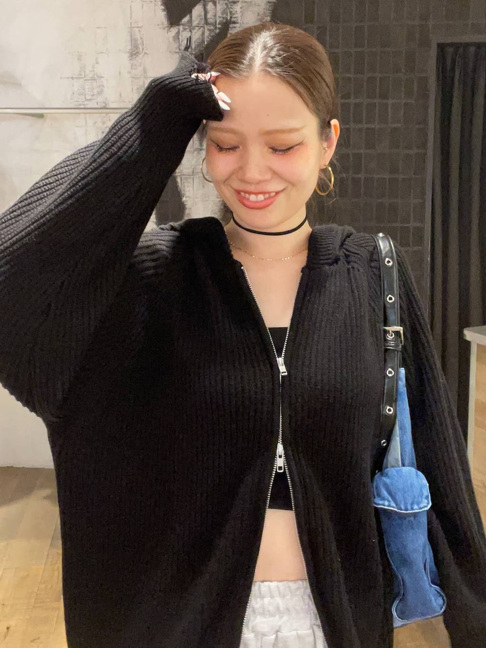 ブルー系のショルダーバッグ、ブラック系のブーツ、グレー系のスウェットパンツを着用したレディースの秋コーディネートの5枚目の写真