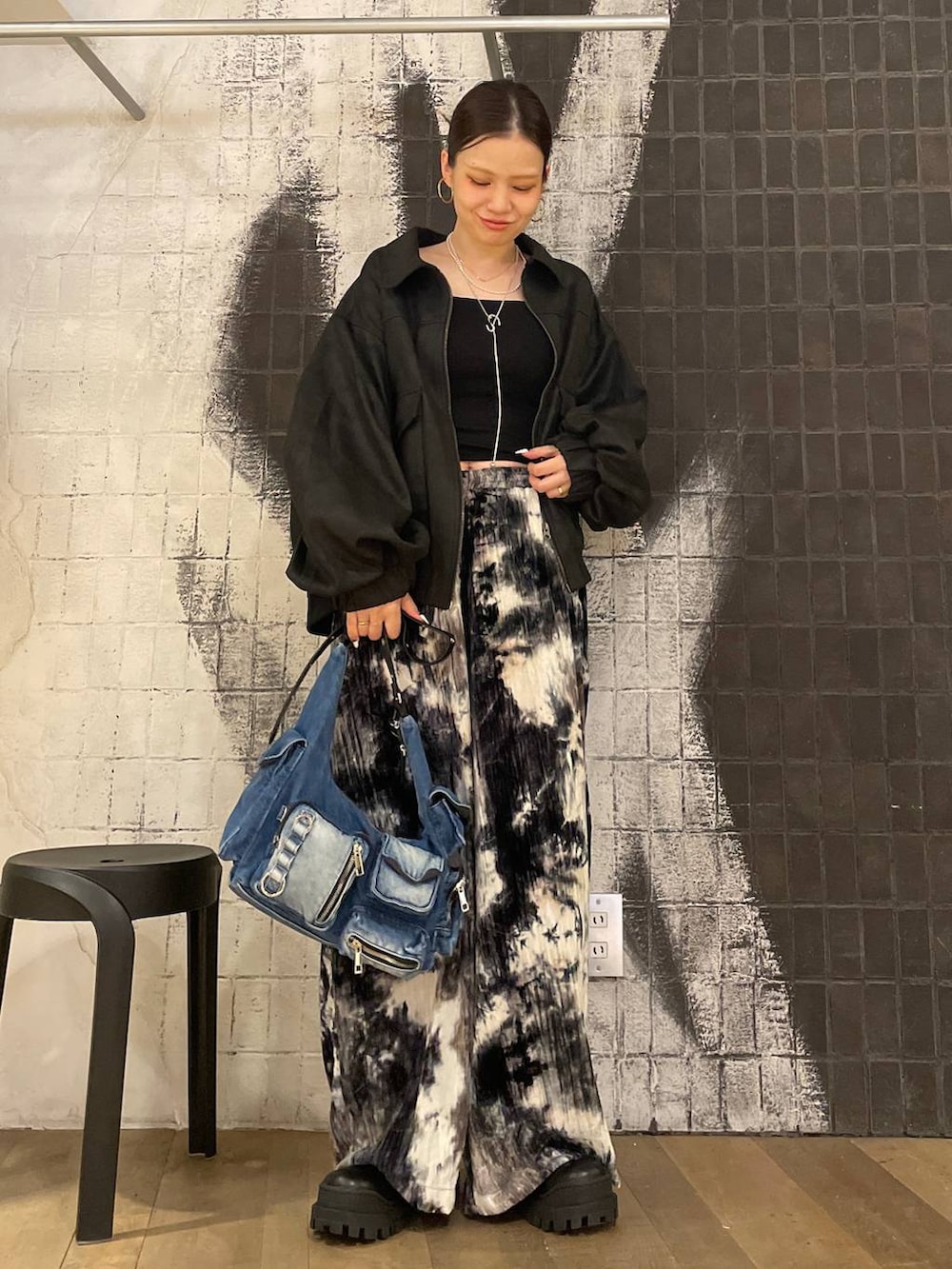 ブラック系のブルゾン、ブルー系のショルダーバッグ、ブラック系のブーツを着用したレディースの秋コーディネートの7枚目の写真