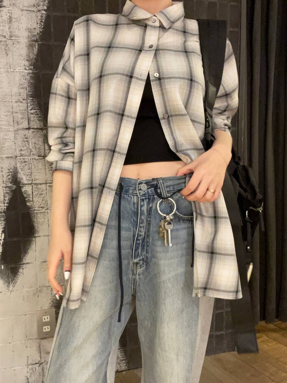 ブラック系のショルダーバッグ、ホワイト系のシャツ/ブラウス、ブラック系のキャミソールを着用したレディースの春コーディネートの3枚目の写真