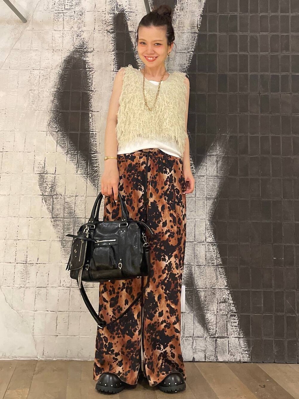 ブラック系のボストンバッグ、ホワイト系のタンクトップ、ブラック系のサンダルを着用したレディースの夏コーディネートの4枚目の写真