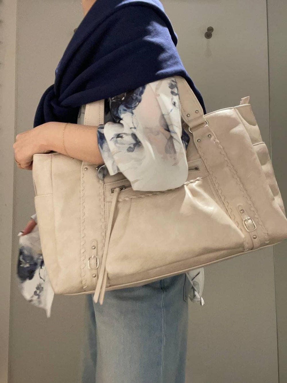 ホワイト系のトートバッグ、ホワイト系のドレスシューズ、ブルー系のスウェットを着用したレディースの春コーディネートの4枚目の写真