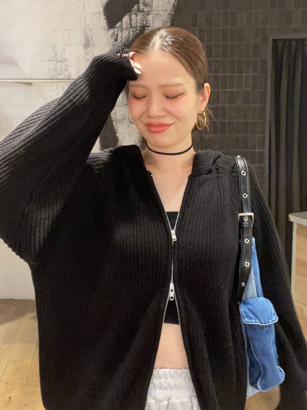 ブルー系のショルダーバッグ、ブラック系のブーツ、グレー系のスウェットパンツを着用したレディースの秋コーディネートの3枚目の写真