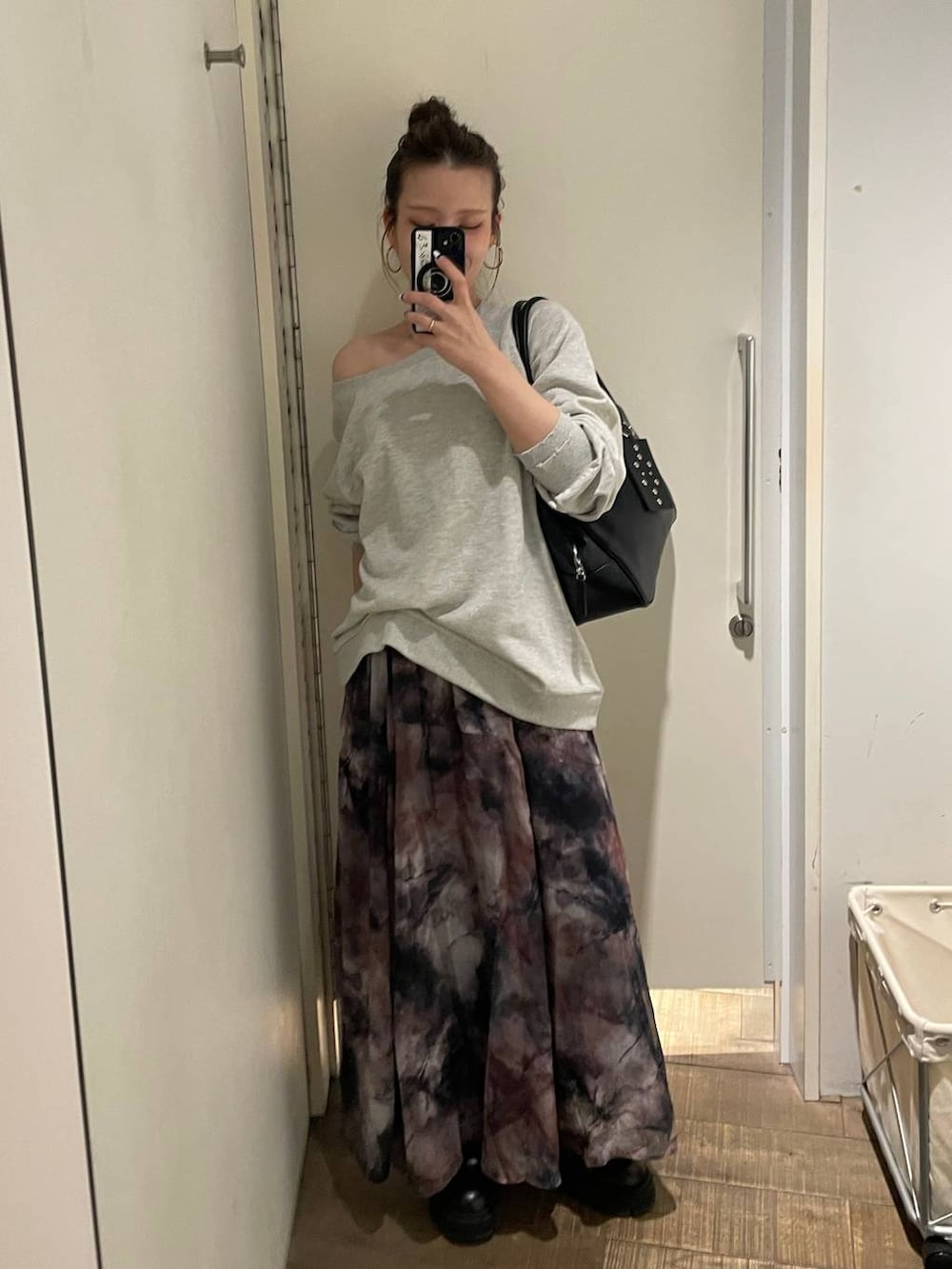 グレー系のスウェット、ブラック系のスカート、ブラック系のボストンバッグを着用したレディースの春コーディネートの3枚目の写真