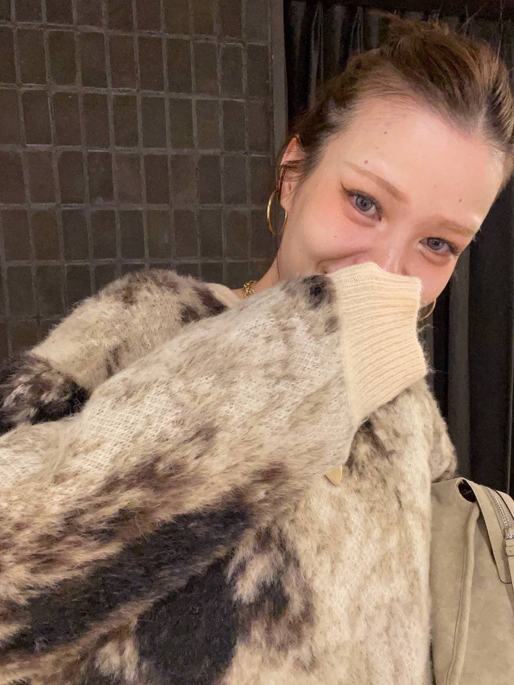 ブラウン系のニット/セーター、ベージュ系のボストンバッグ、ブラック系のブーツを着用したレディースの秋コーディネートの7枚目の写真