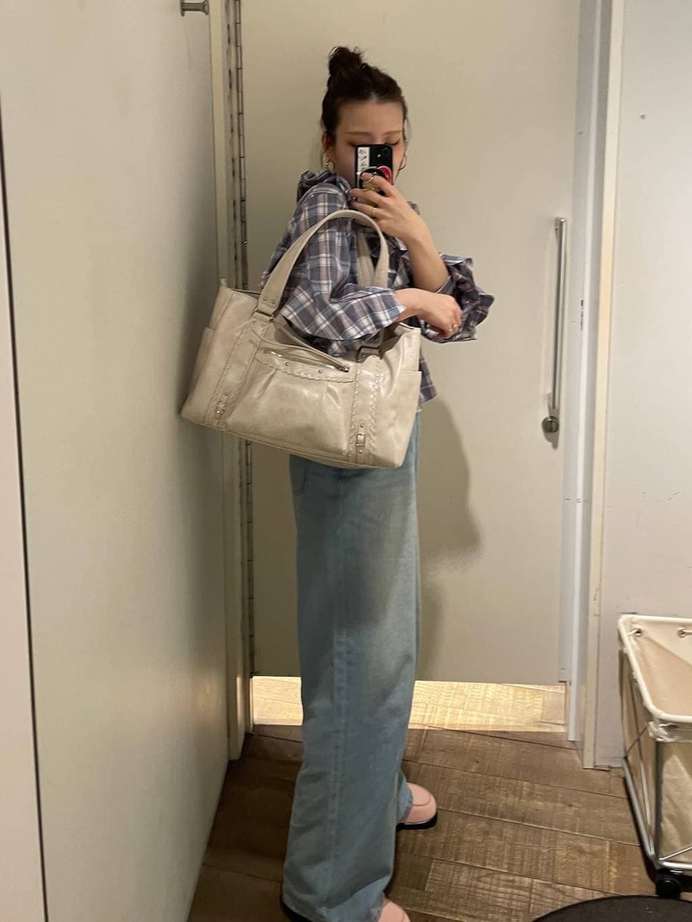 ピンク系のローファー、ホワイト系のトートバッグ、ブルー系のデニムパンツを着用したレディースの春コーディネートの4枚目の写真