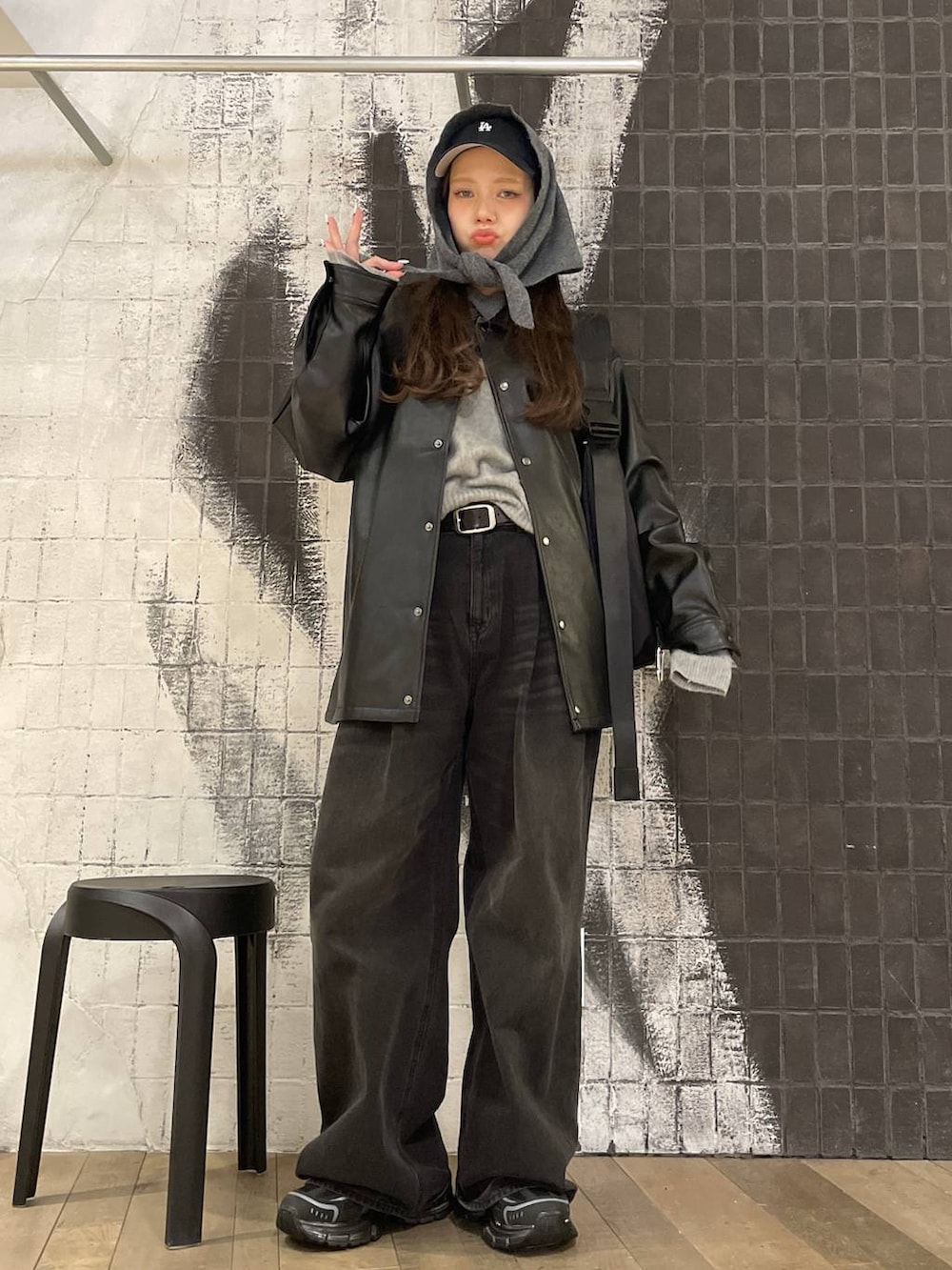 ブラック系のショルダーバッグ、グレー系のデニムパンツ、ブラック系のライダースジャケットを着用したレディースの秋コーディネートの5枚目の写真