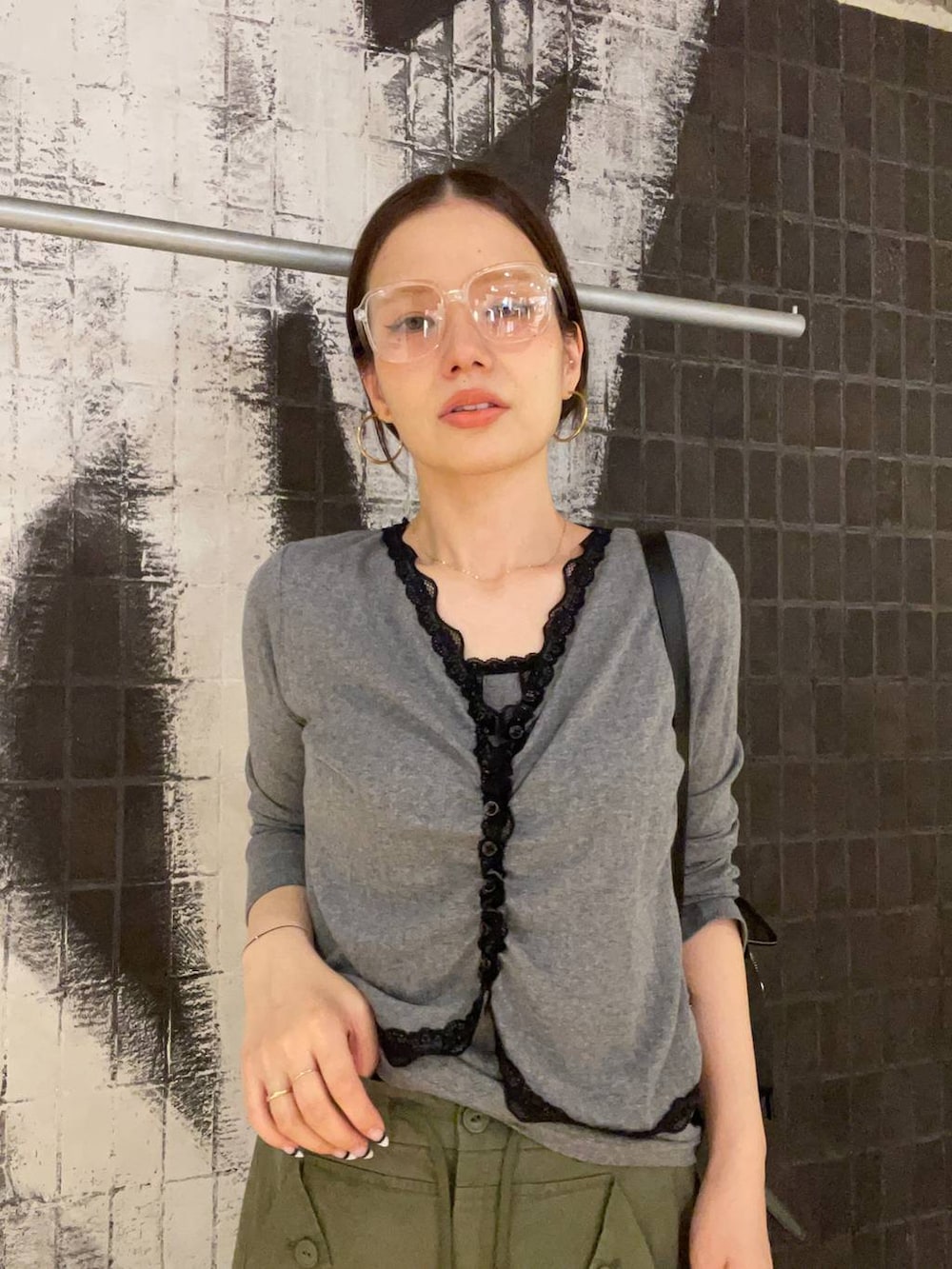 グリーン系のカーゴパンツ、ブラック系のバックパック/リュック、グレー系のカーディガン/ボレロを着用したレディースの夏コーディネートの2枚目の写真
