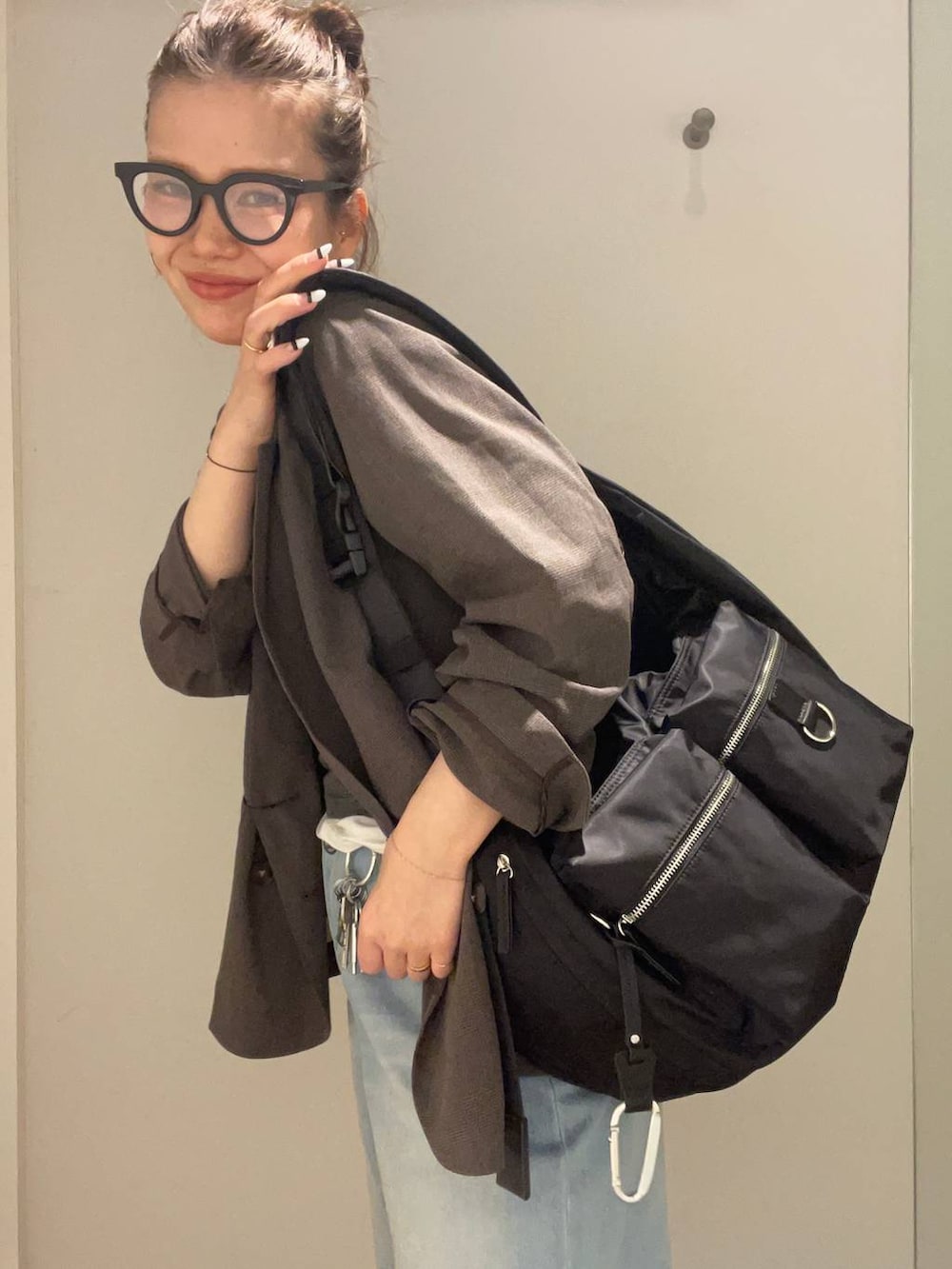 ブラック系のショルダーバッグ、ホワイト系のTシャツ/カットソー、ブラック系のローファーを着用したレディースの春コーディネートの5枚目の写真