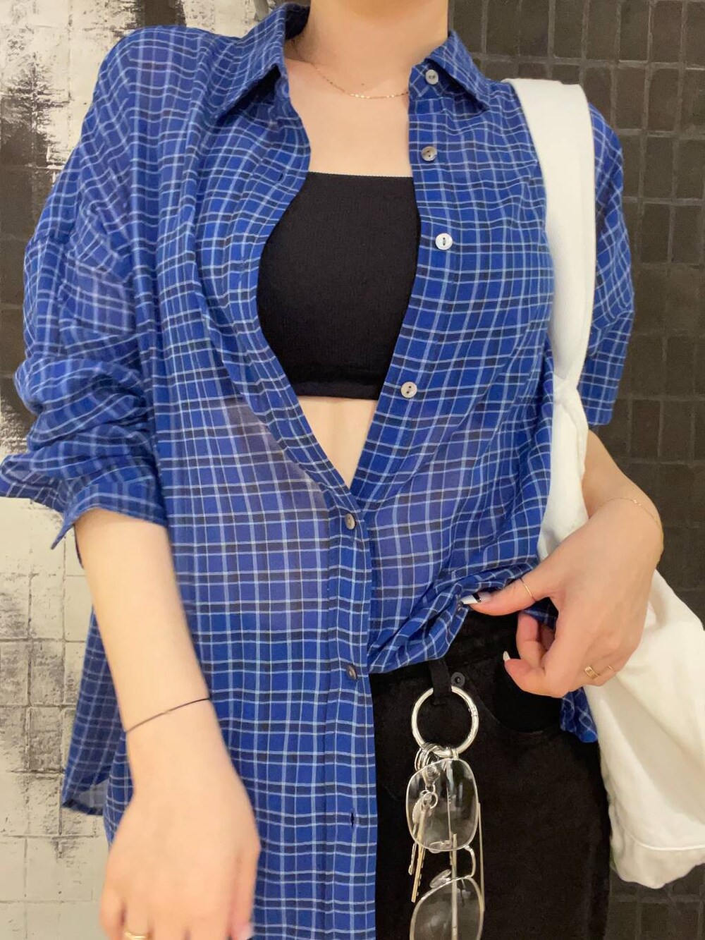ブラック系のデニムパンツ、ブラック系のサンダル、ブルー系のシャツ/ブラウスを着用したレディースの春コーディネートの2枚目の写真