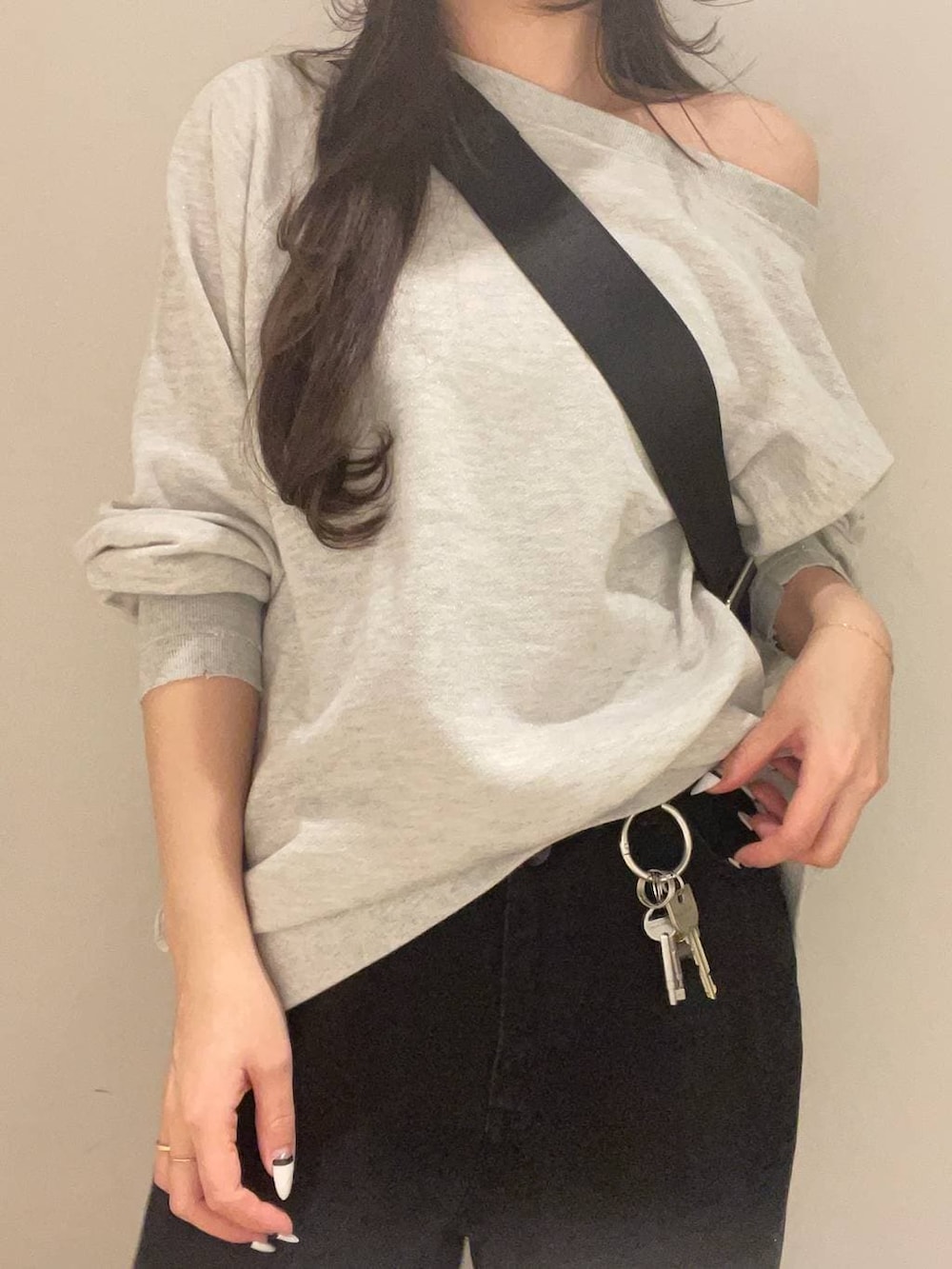 グレー系のスウェット、ブラック系のトートバッグ、ブラック系のデニムパンツを着用したレディースの冬コーディネートの3枚目の写真