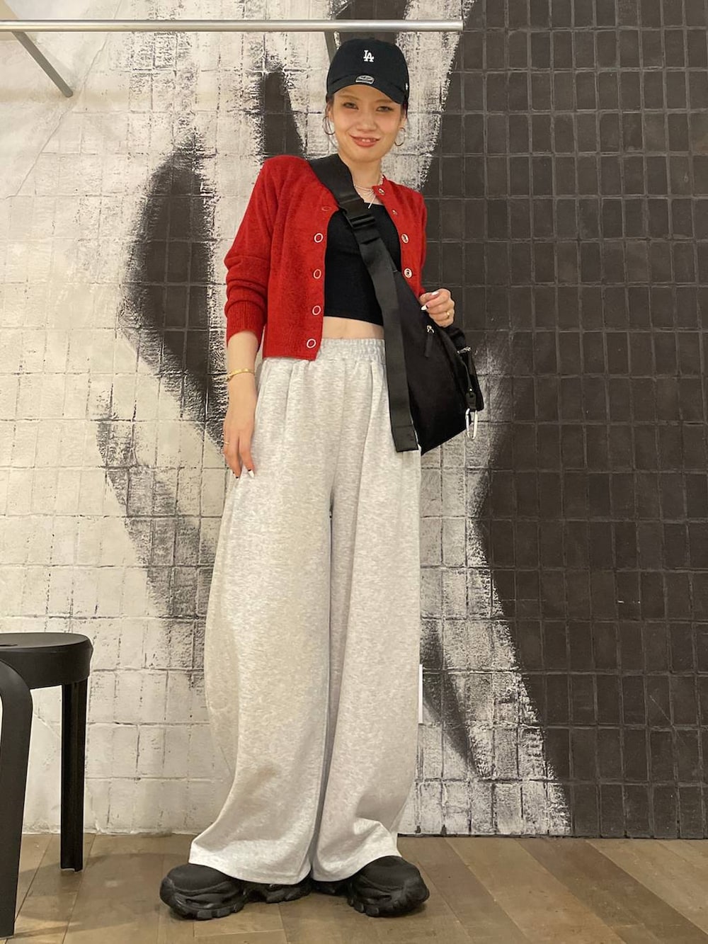 ブラック系のショルダーバッグ、ブラック系のブーツ、グレー系のスウェットパンツを着用したレディースの秋コーディネートの2枚目の写真