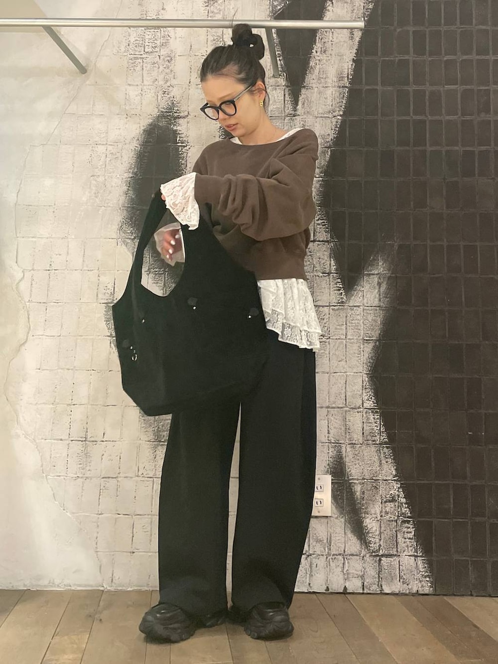 ブラック系のローファー、ブラウン系のスウェット、ブラック系のトートバッグを着用したレディースの冬コーディネートの4枚目の写真