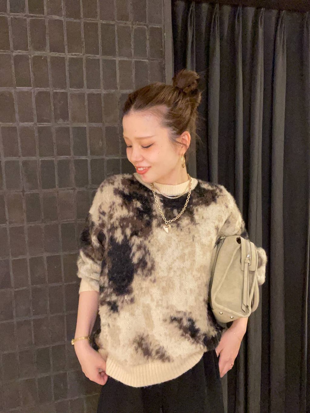 ブラウン系のニット/セーター、ベージュ系のボストンバッグ、ブラック系のブーツを着用したレディースの秋コーディネートの3枚目の写真